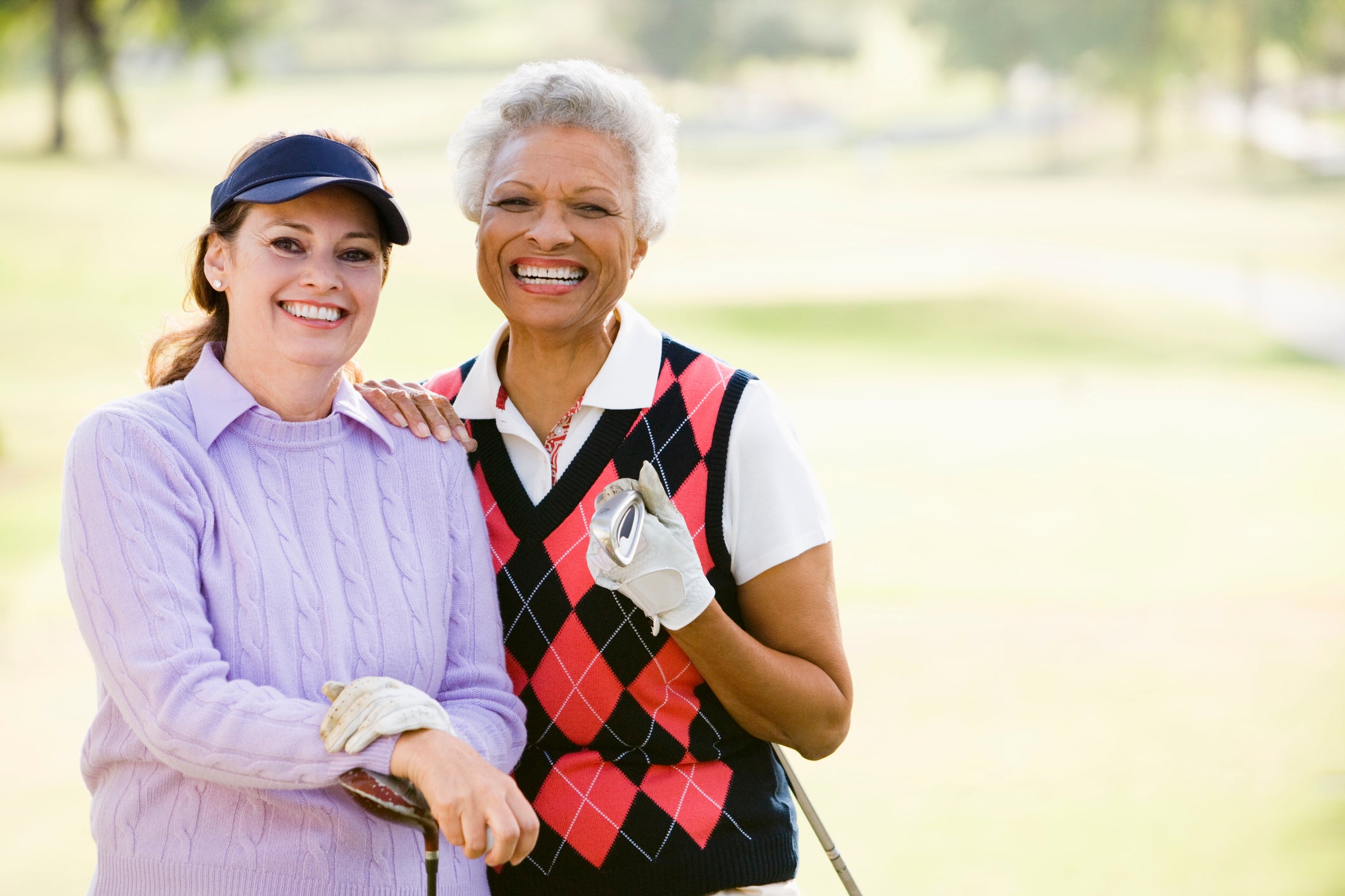 Two women standing on a golf course