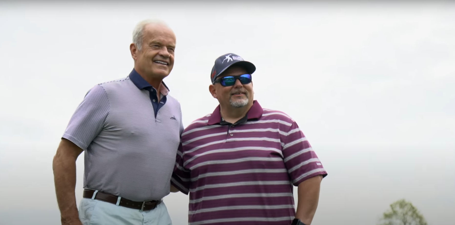 Kelsey Grammer standing with golfer.