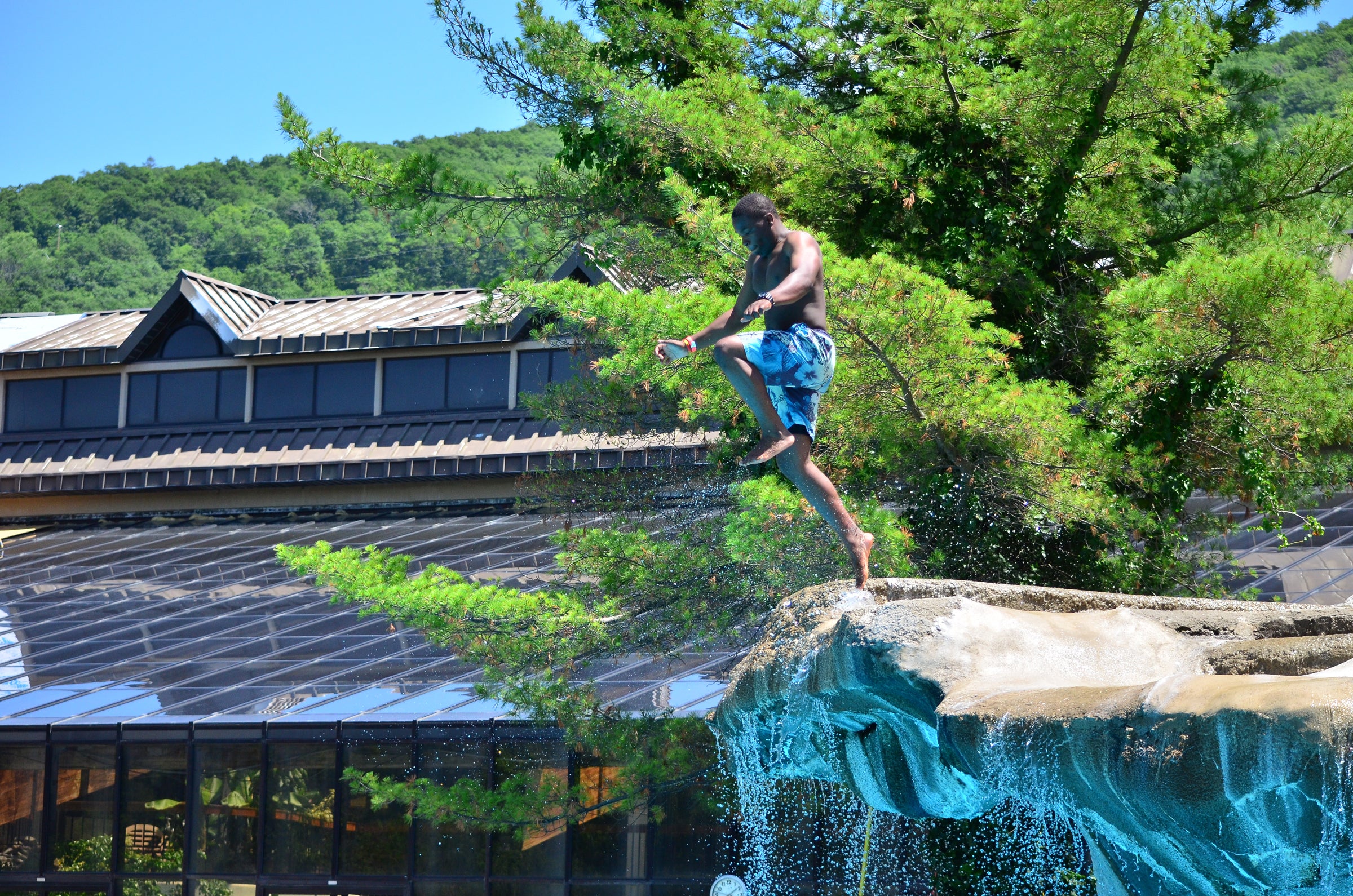 Young boy cannonballing off cliff jump at Minerals Hotel