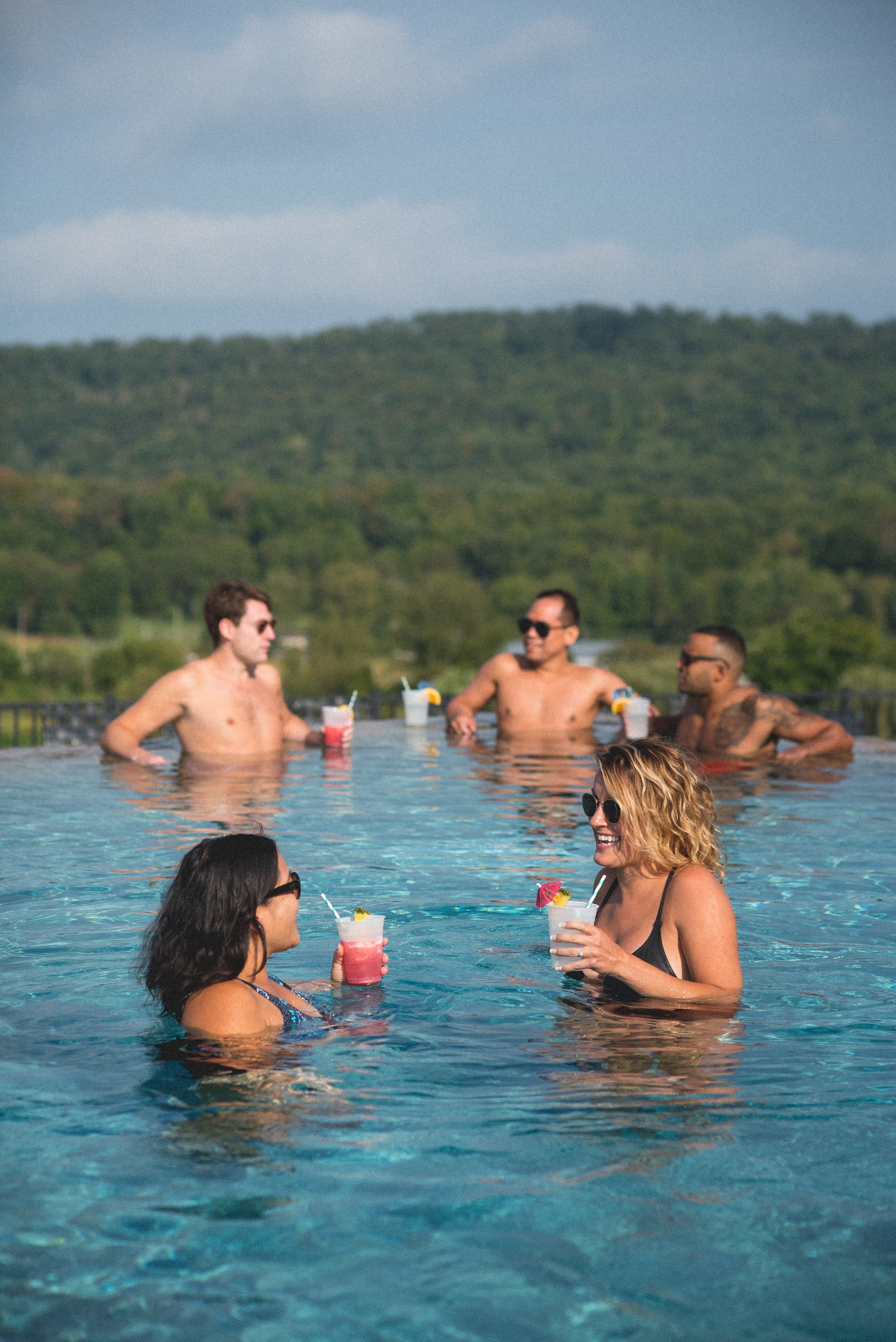 Group of friends drinking in Vista 180 pool.