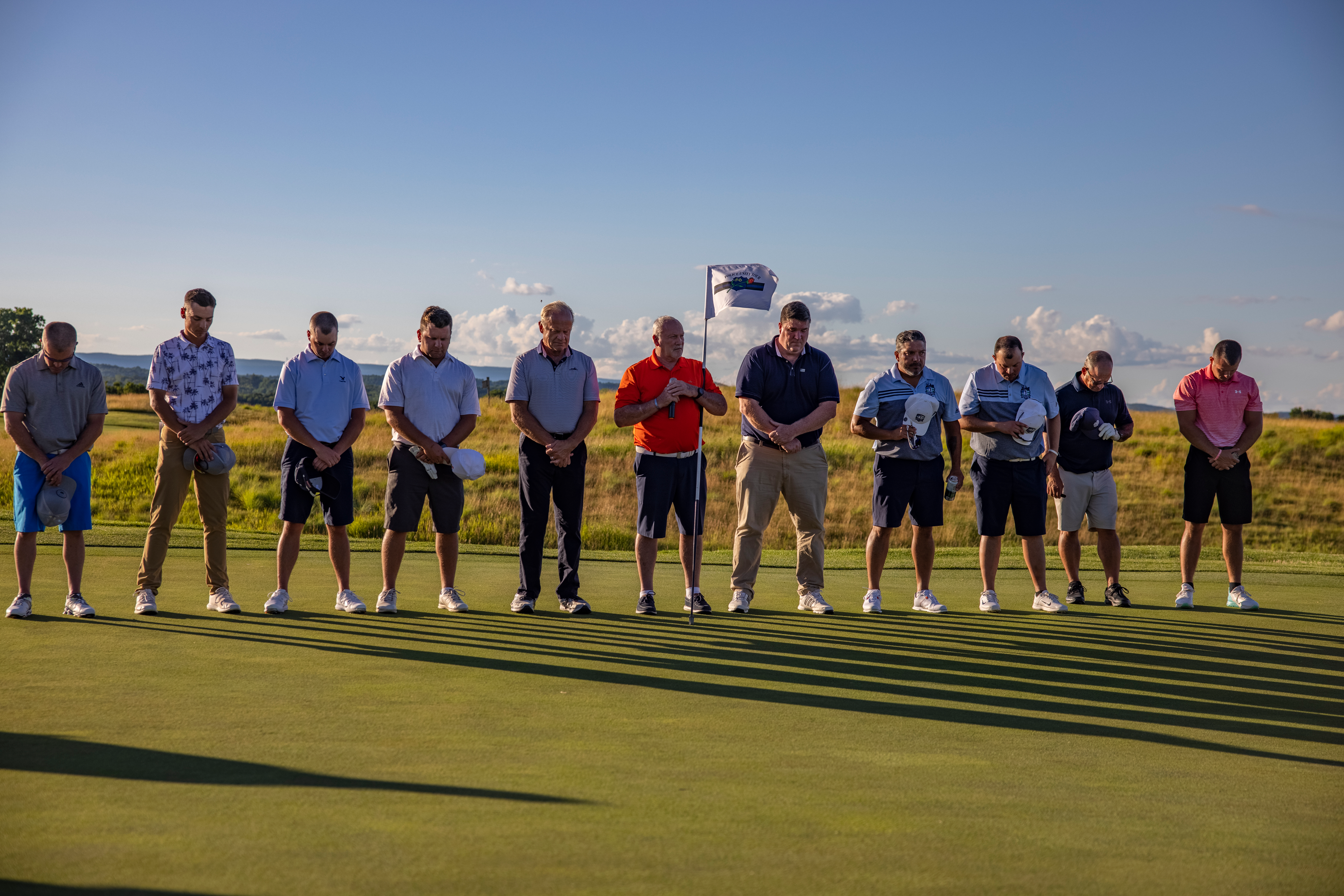 Golfers standing in a line listening to the National Anthem