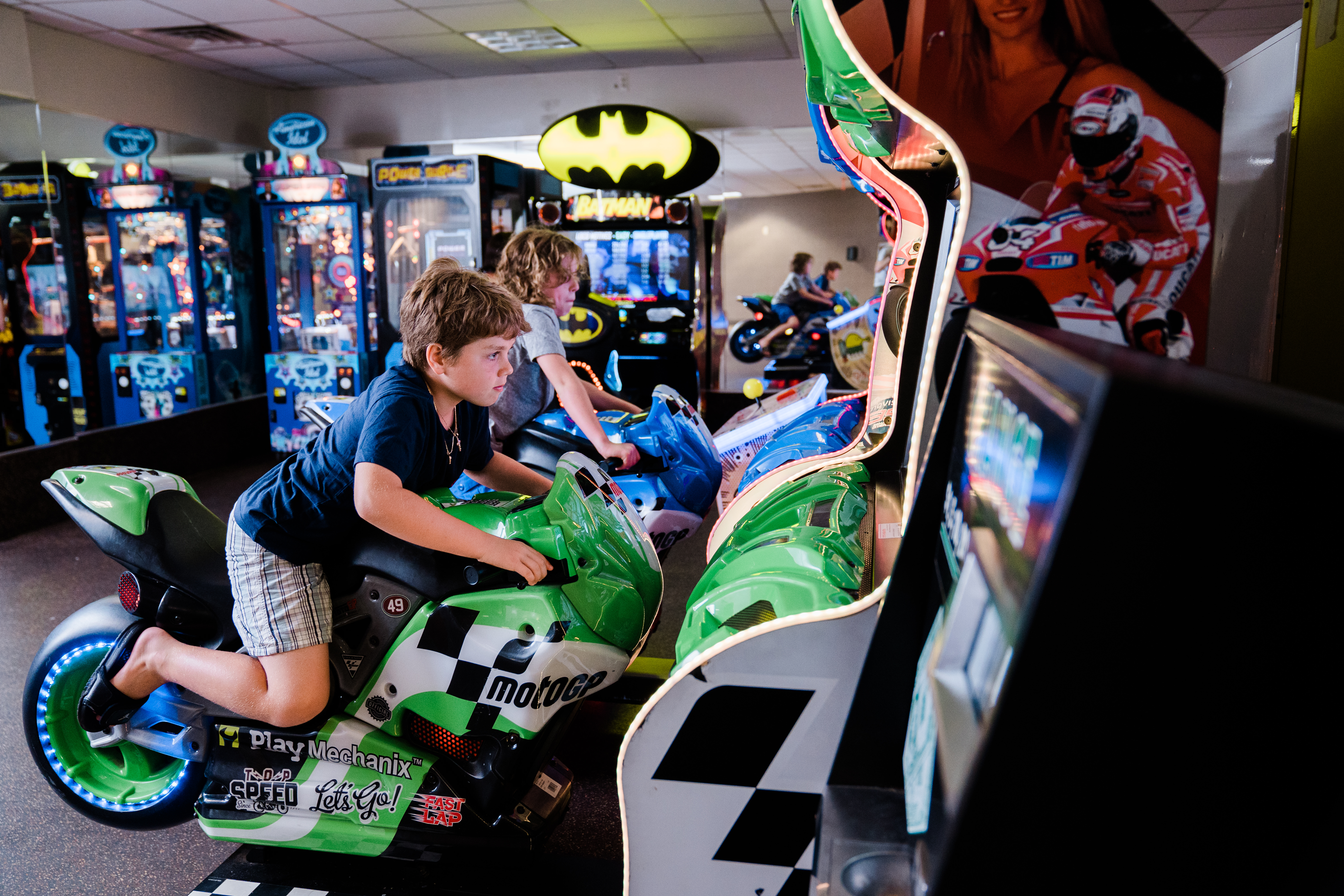 Young boy on motorcycle arcade game.