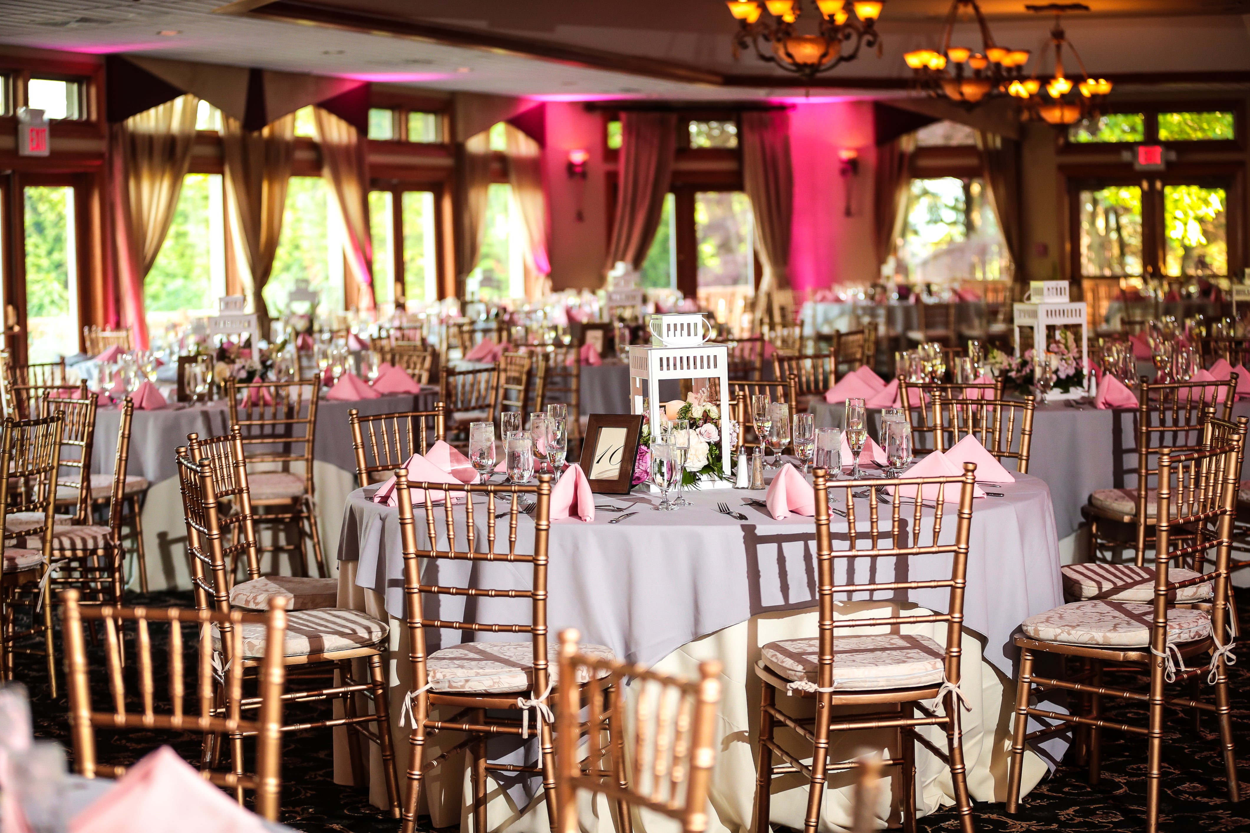 Wedding reception tables with pink uplighting at Black Bear Golf Club.