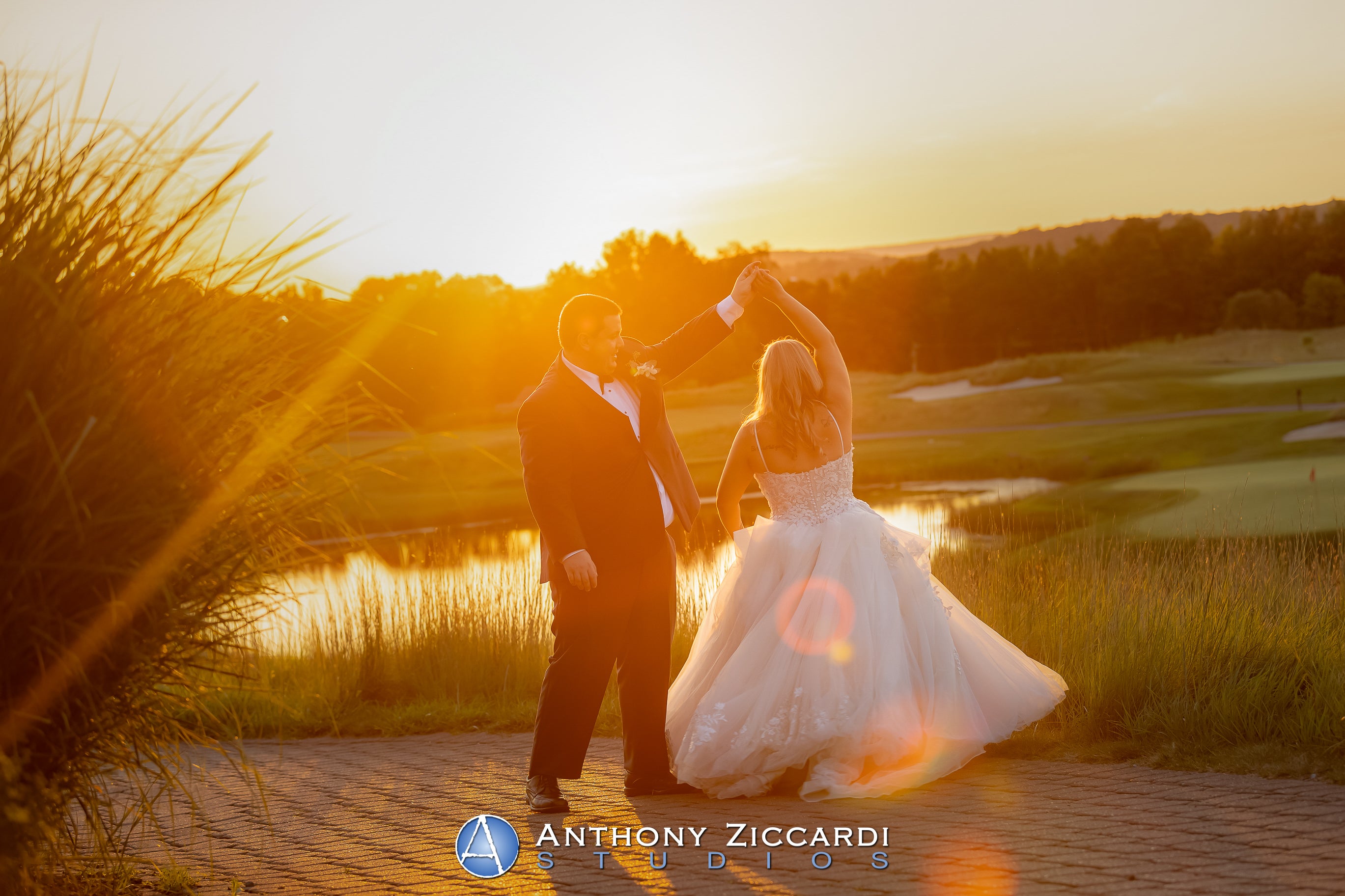 Groom twirling his bride with sunsetting