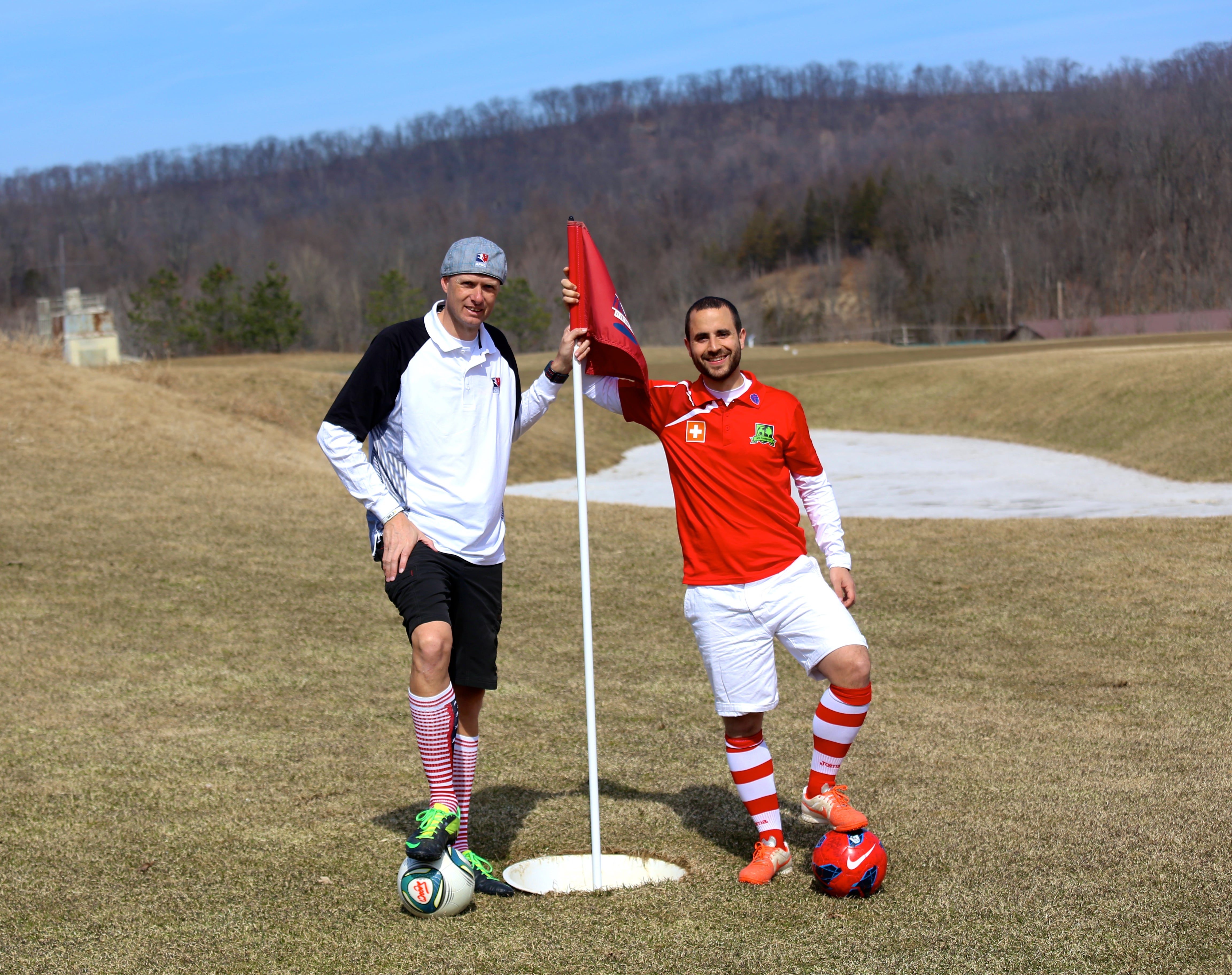 Guys standing on a foot golf hole flag
