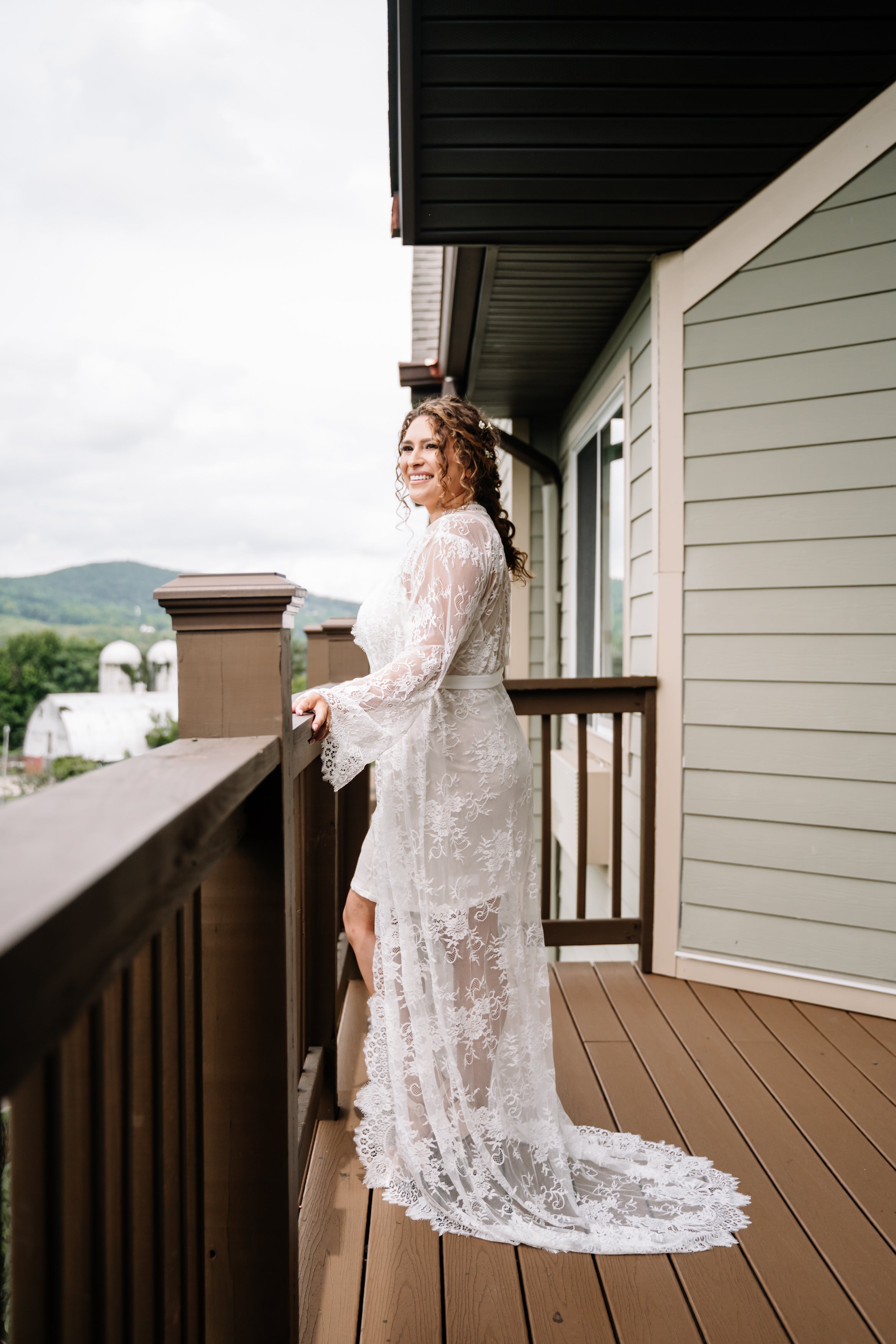 Beautiful bride in wedding dress standing looking over balcony
