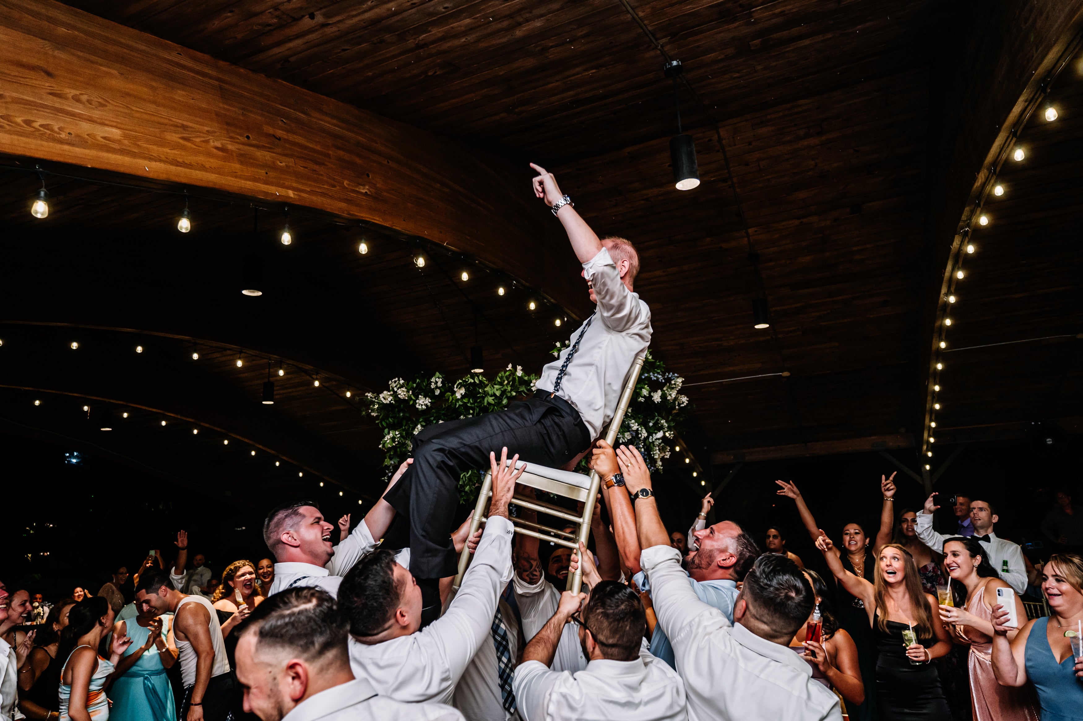 Groom raised on chair during wedding reception in Sweetgrass Pavilion