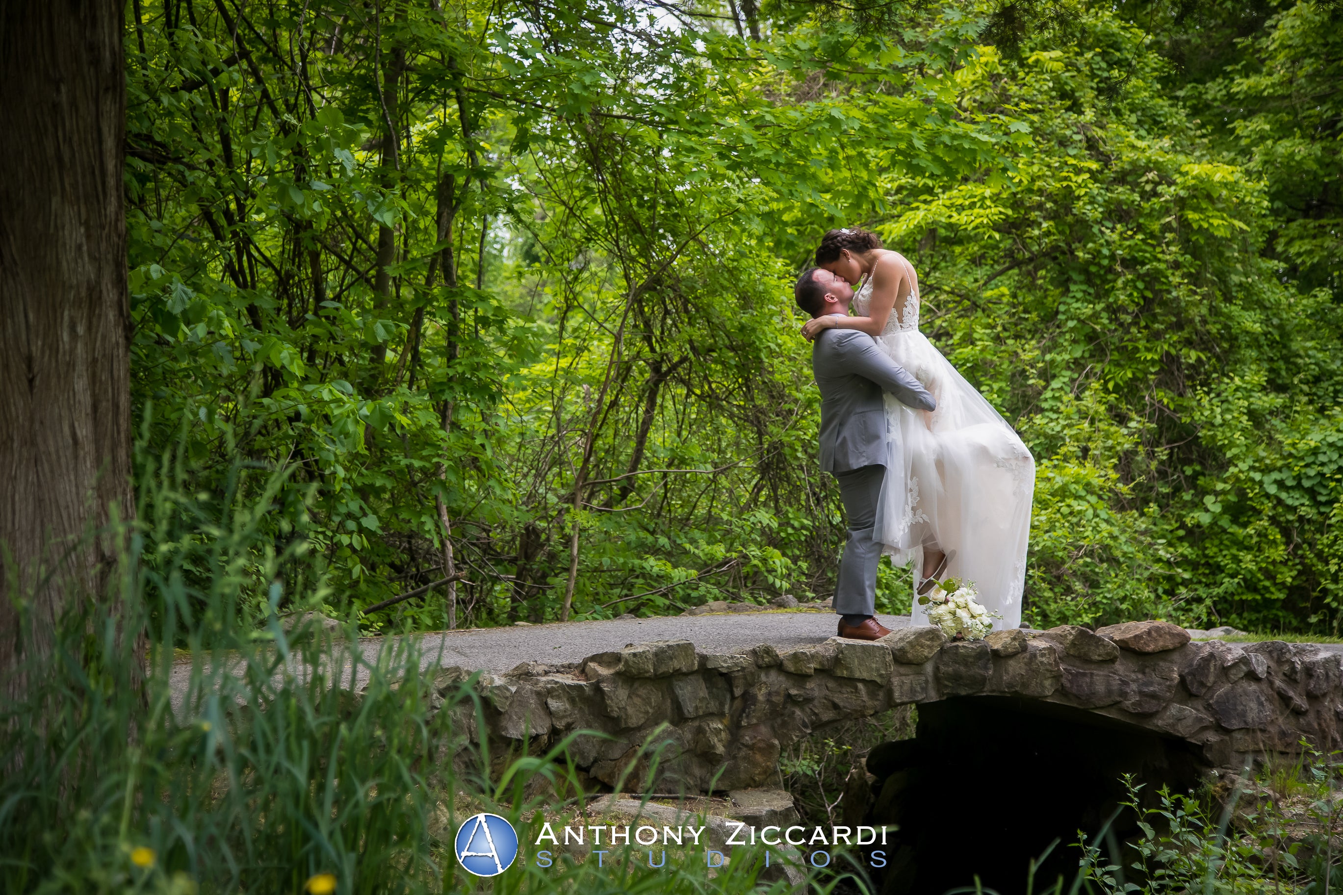 Groom lifting up bride in wedding photo op