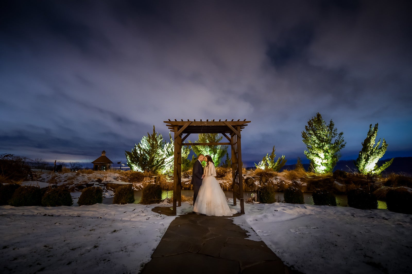 Wedding couple standing under alter at night