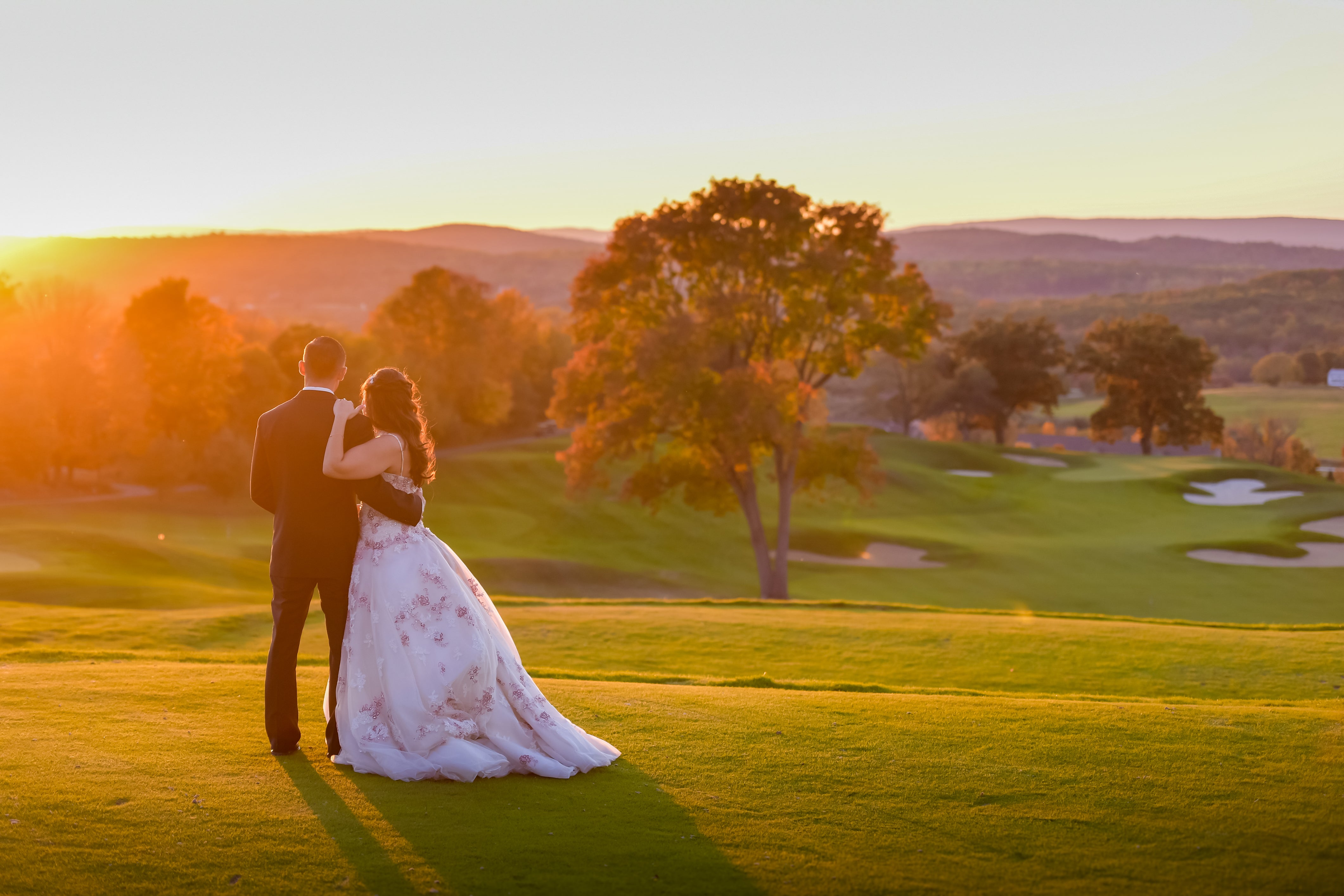 Wedding couple overlooking golf course at sunset