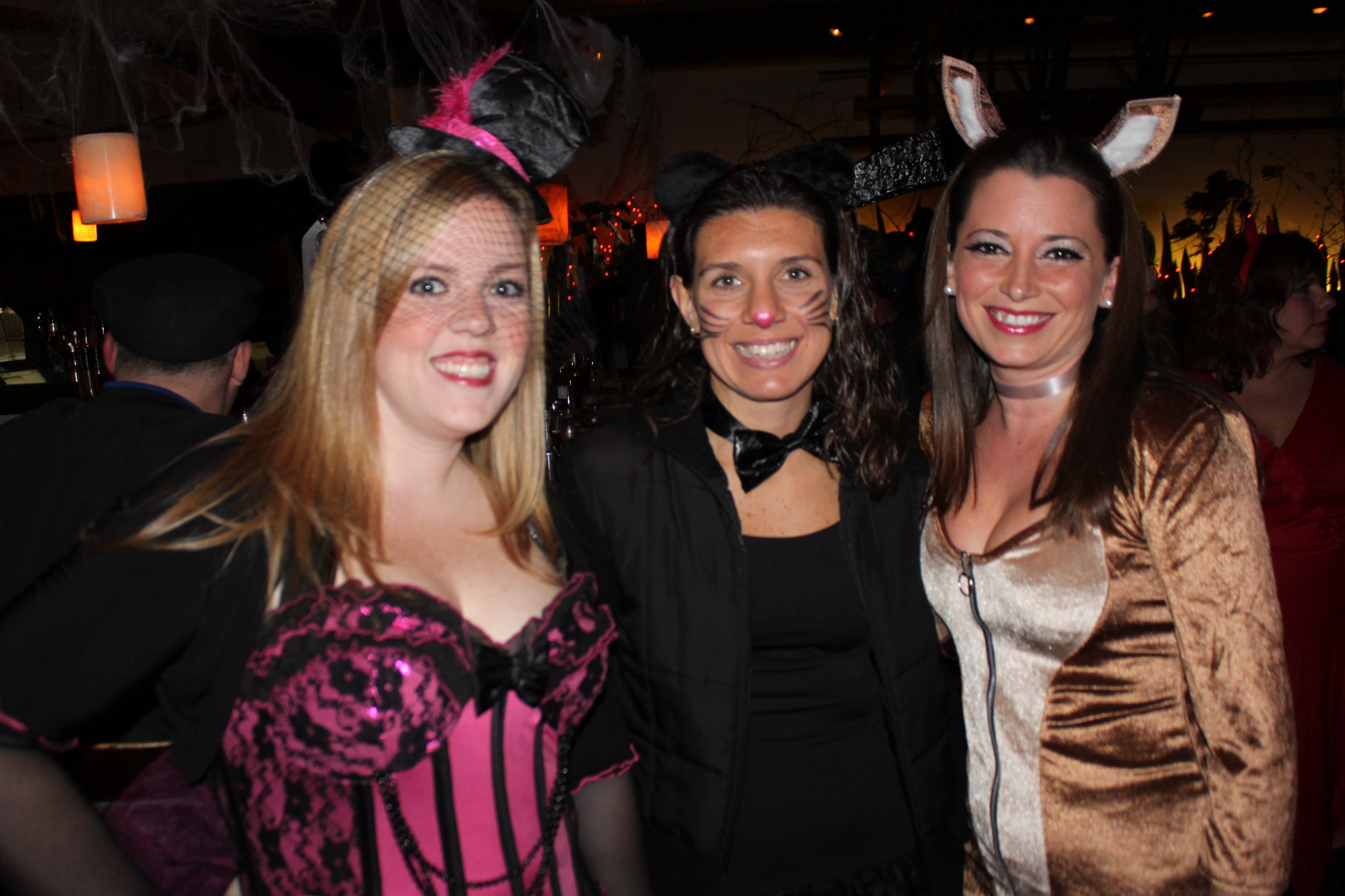 Three women dressed up in halloween costumes.