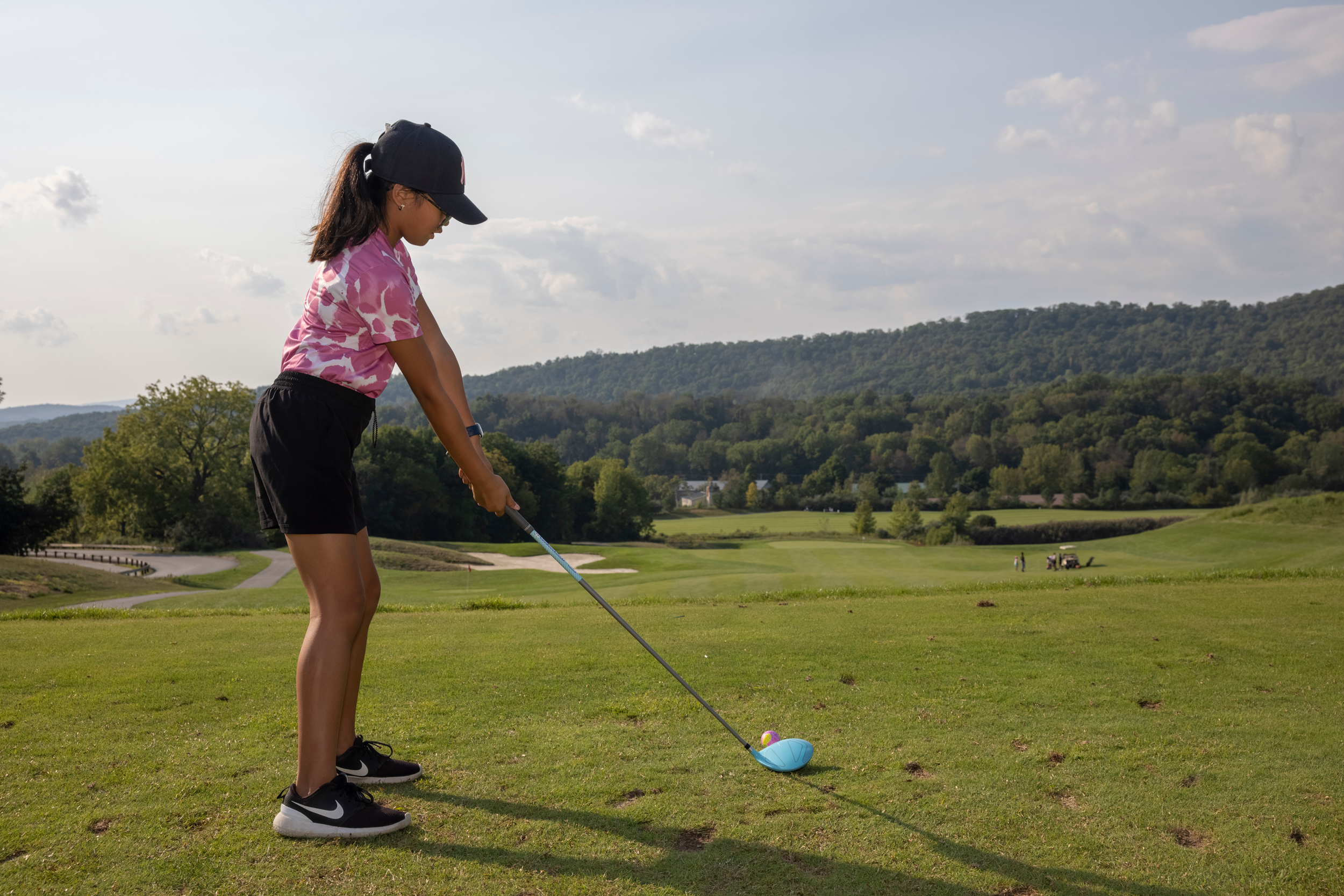 Young girl lining up her swing to golf
