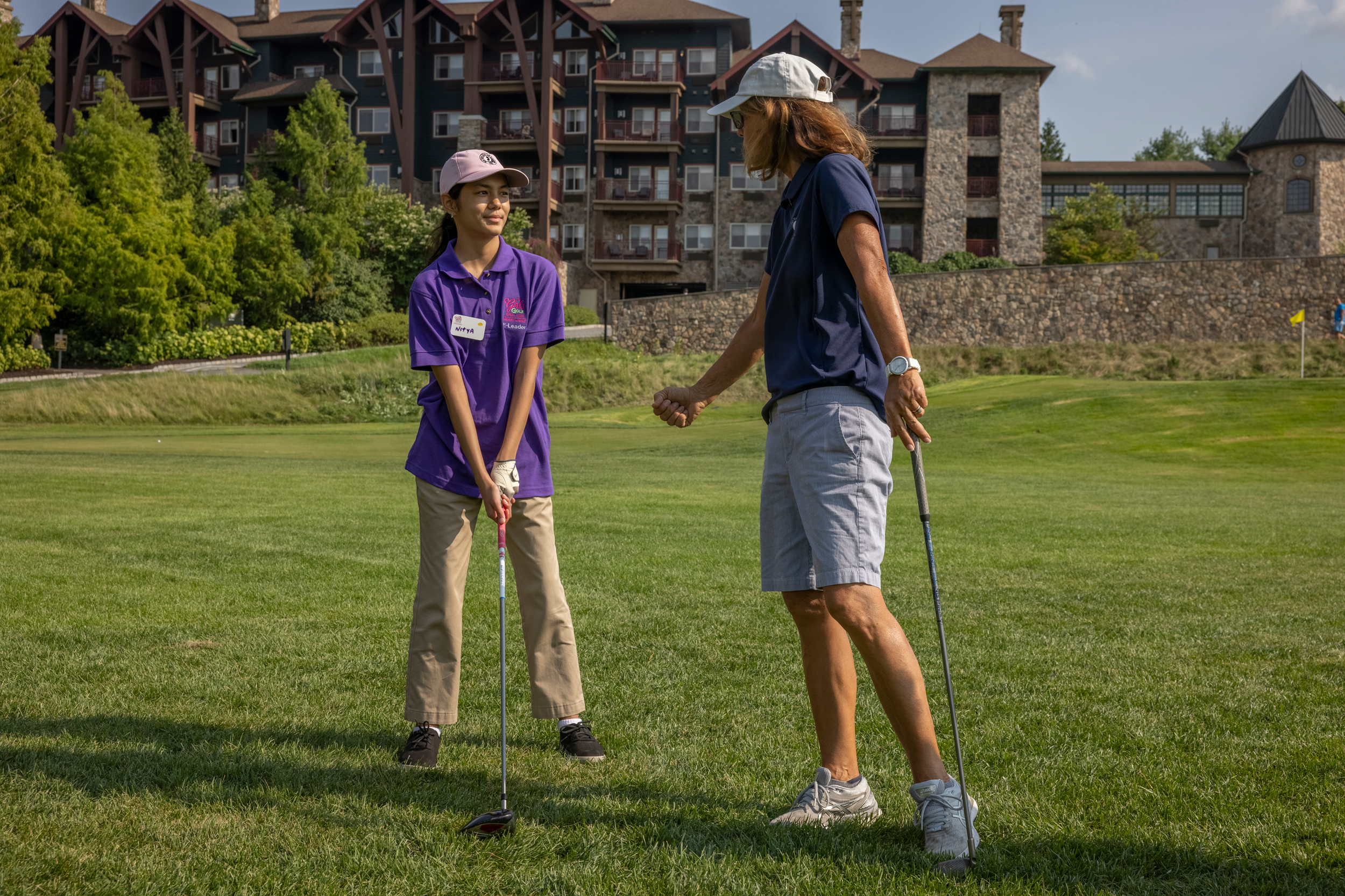 Golf instructor teaching girl to golf at Crystal Springs Resort