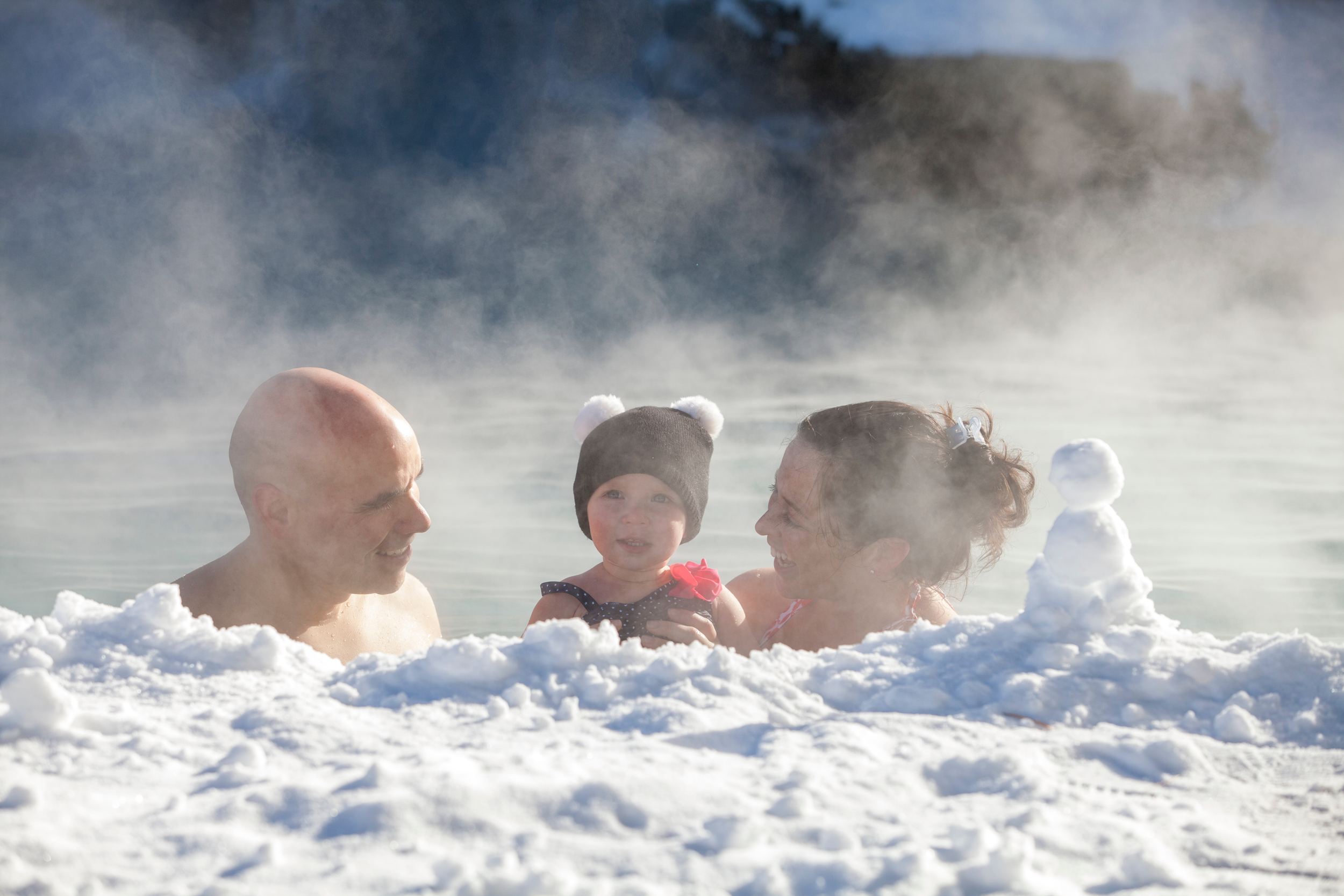 Parents and child swimming in snow pool at Minerals Hotel