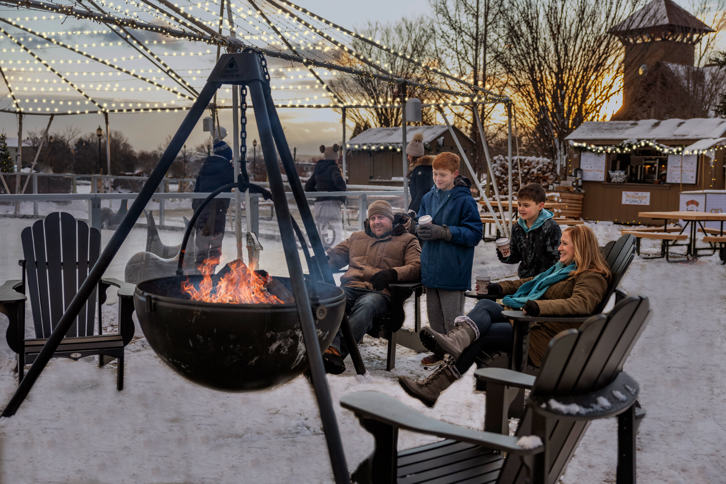 Family sitting by fire pit at Schnapps Shack