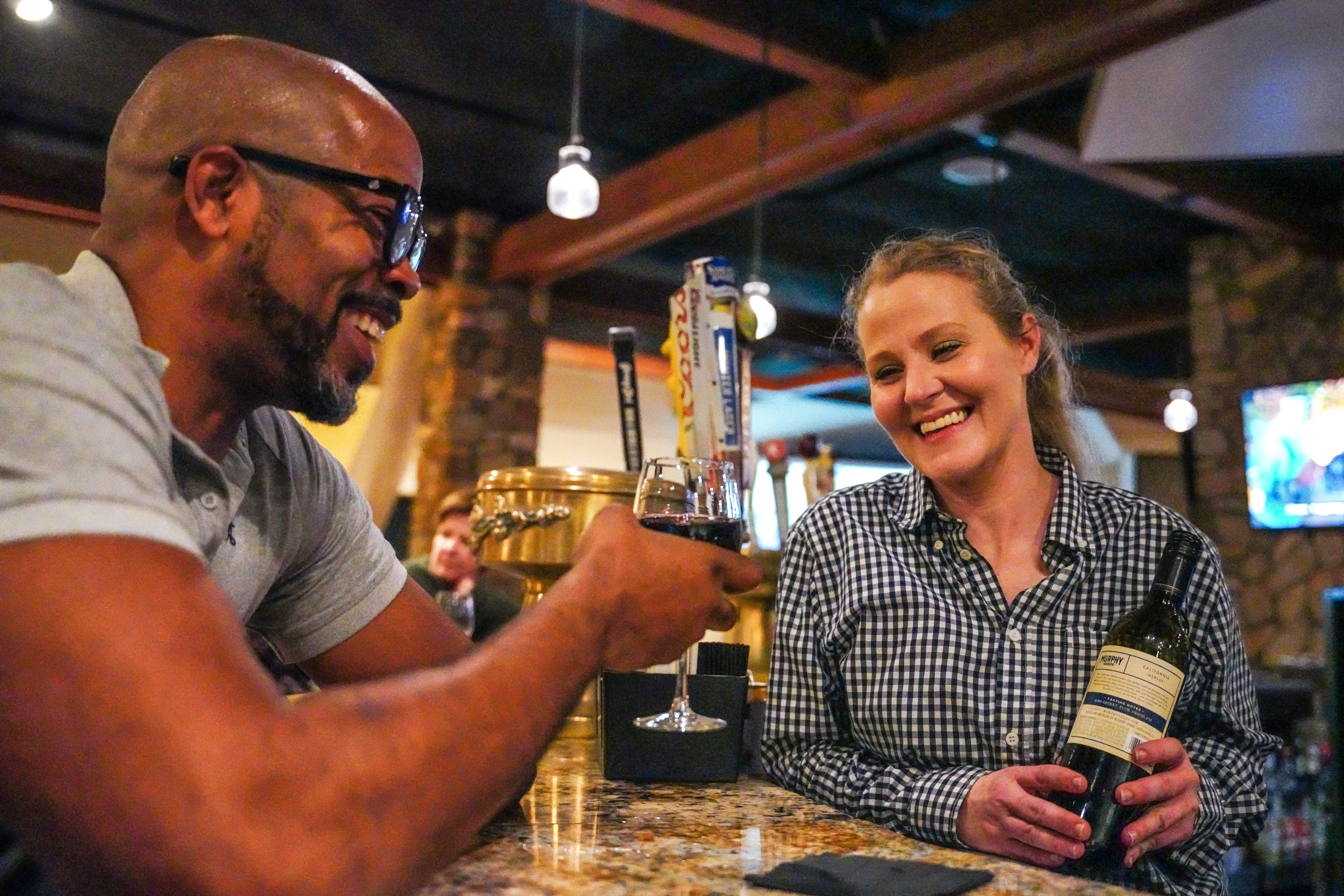 Bartender serving red wine to man at Kites Restaurant