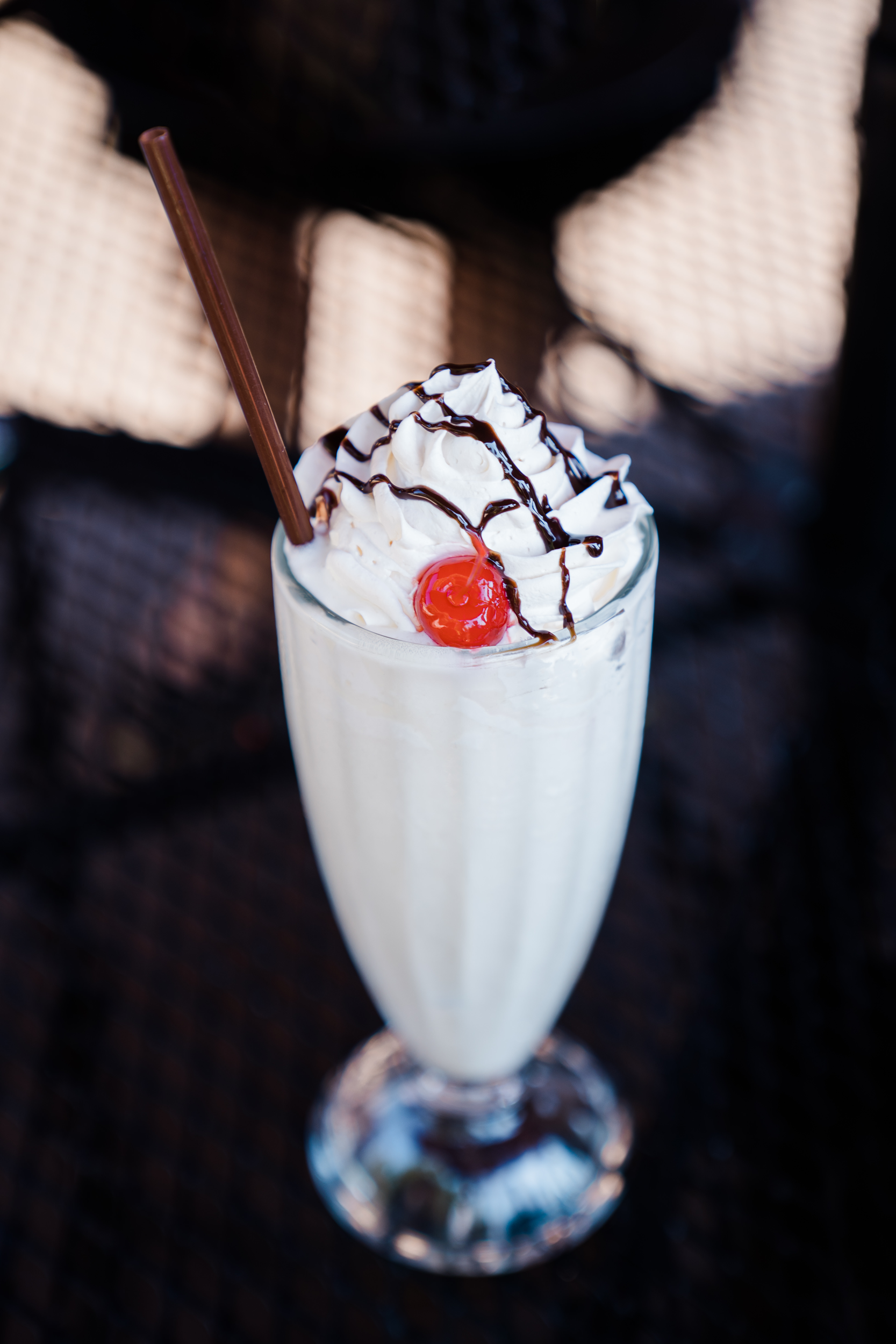 Vanilla milkshake with whipped cream and a cherry on top