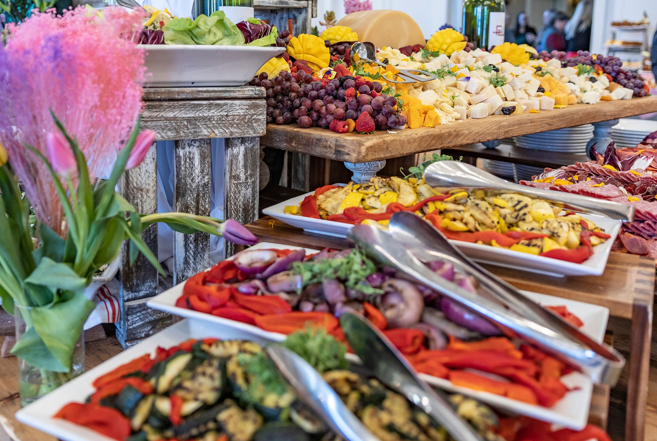 Food display of cheese, fruit and array of other things.