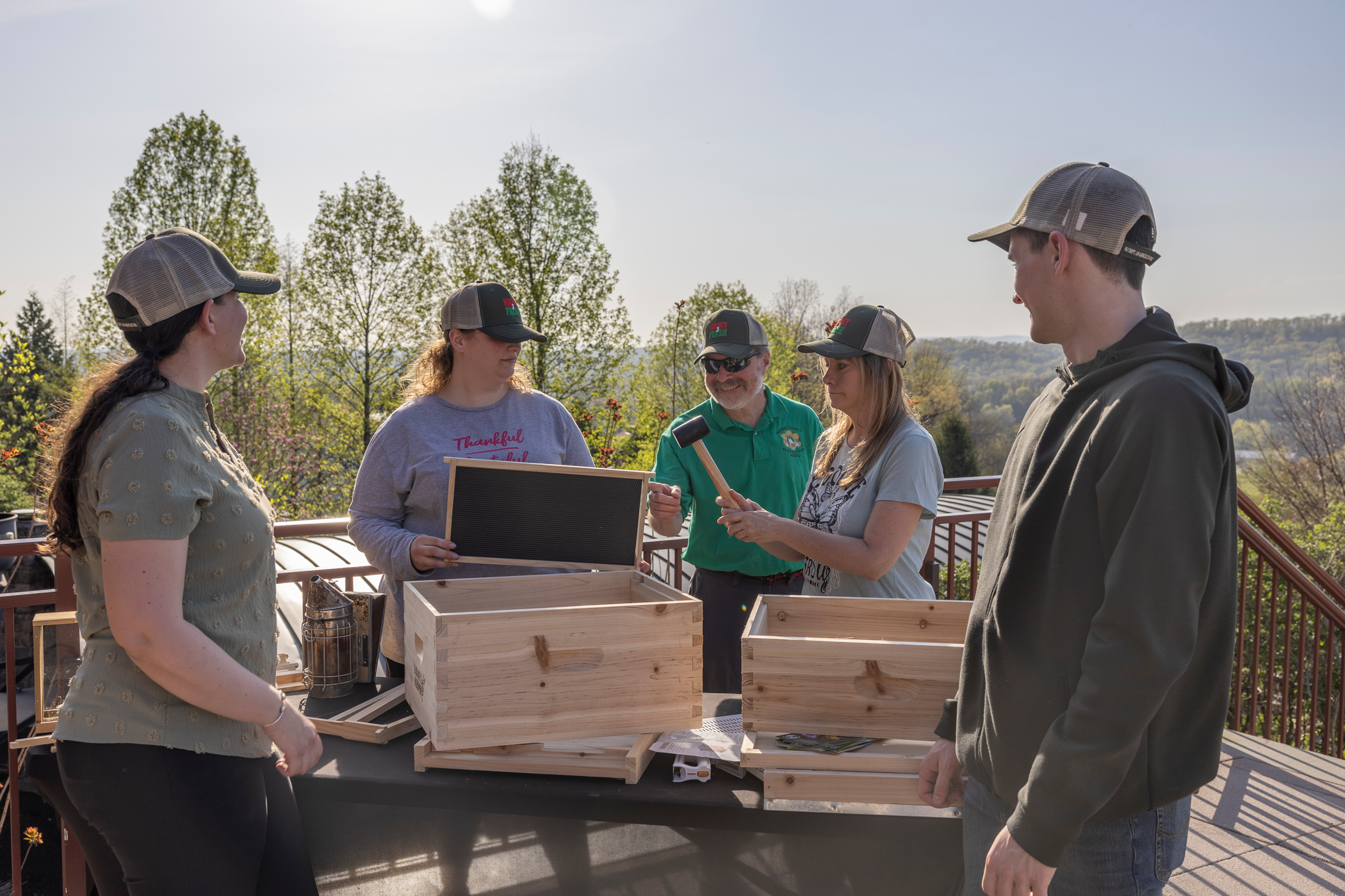 Group of people learning how to build a bee hive box.
