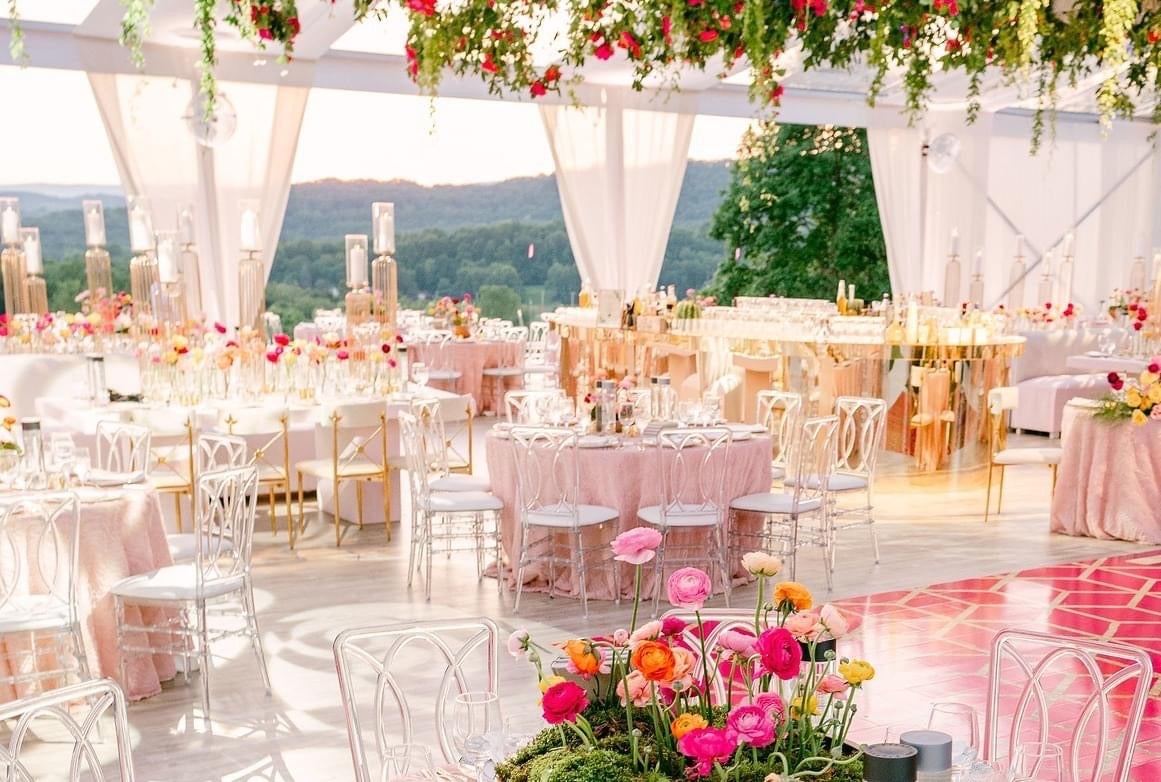 Wedding reception in Big Sky Pavillion featuring pink tablecloths and bright florals.