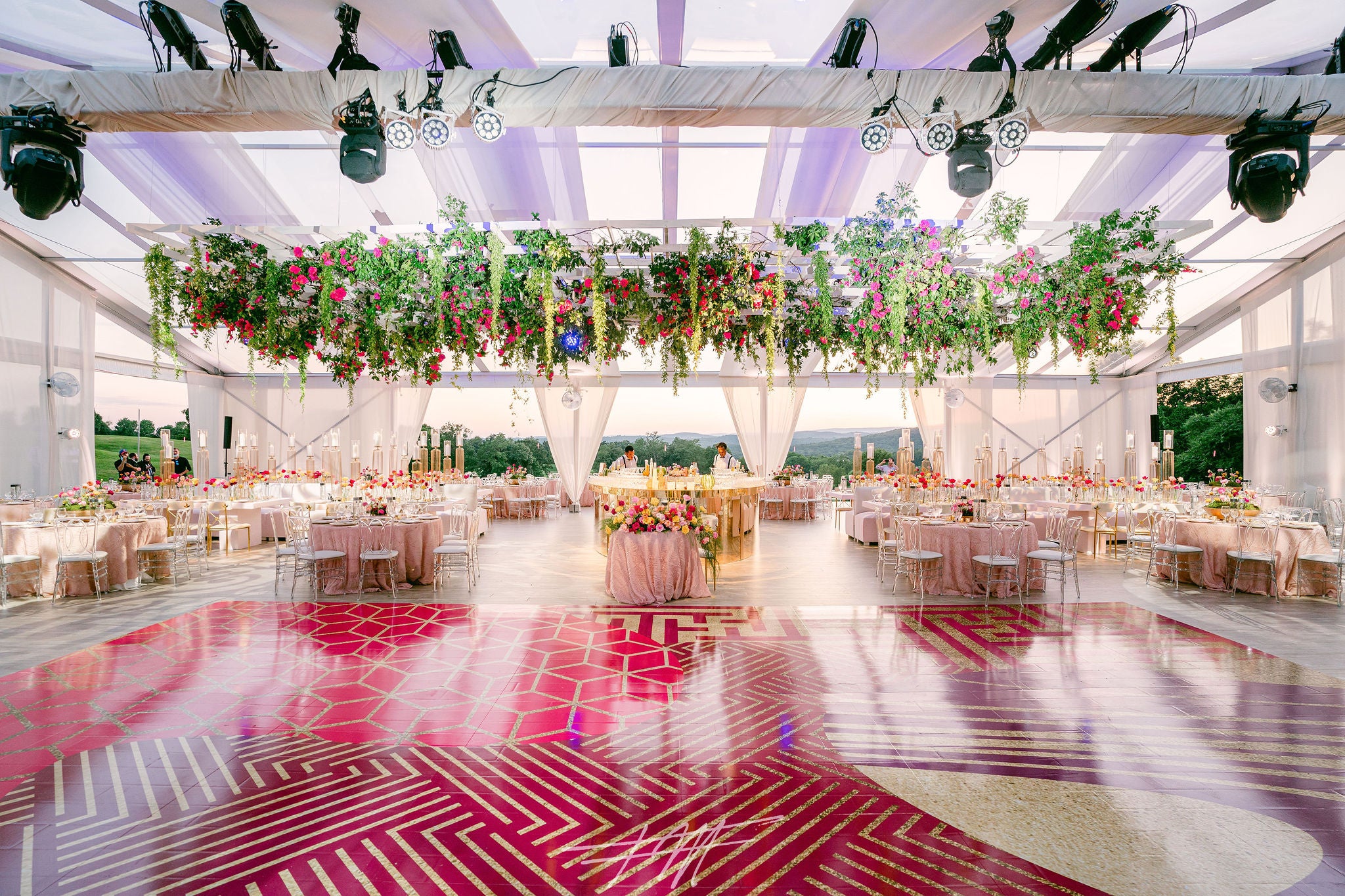 Wedding reception featuring pink dance floor and florals in Big Sky Pavillion.