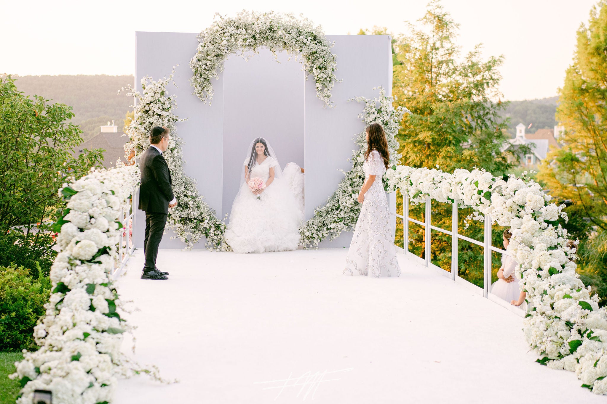 Bride walking down aisle during wedding ceremony in amphitheater. 