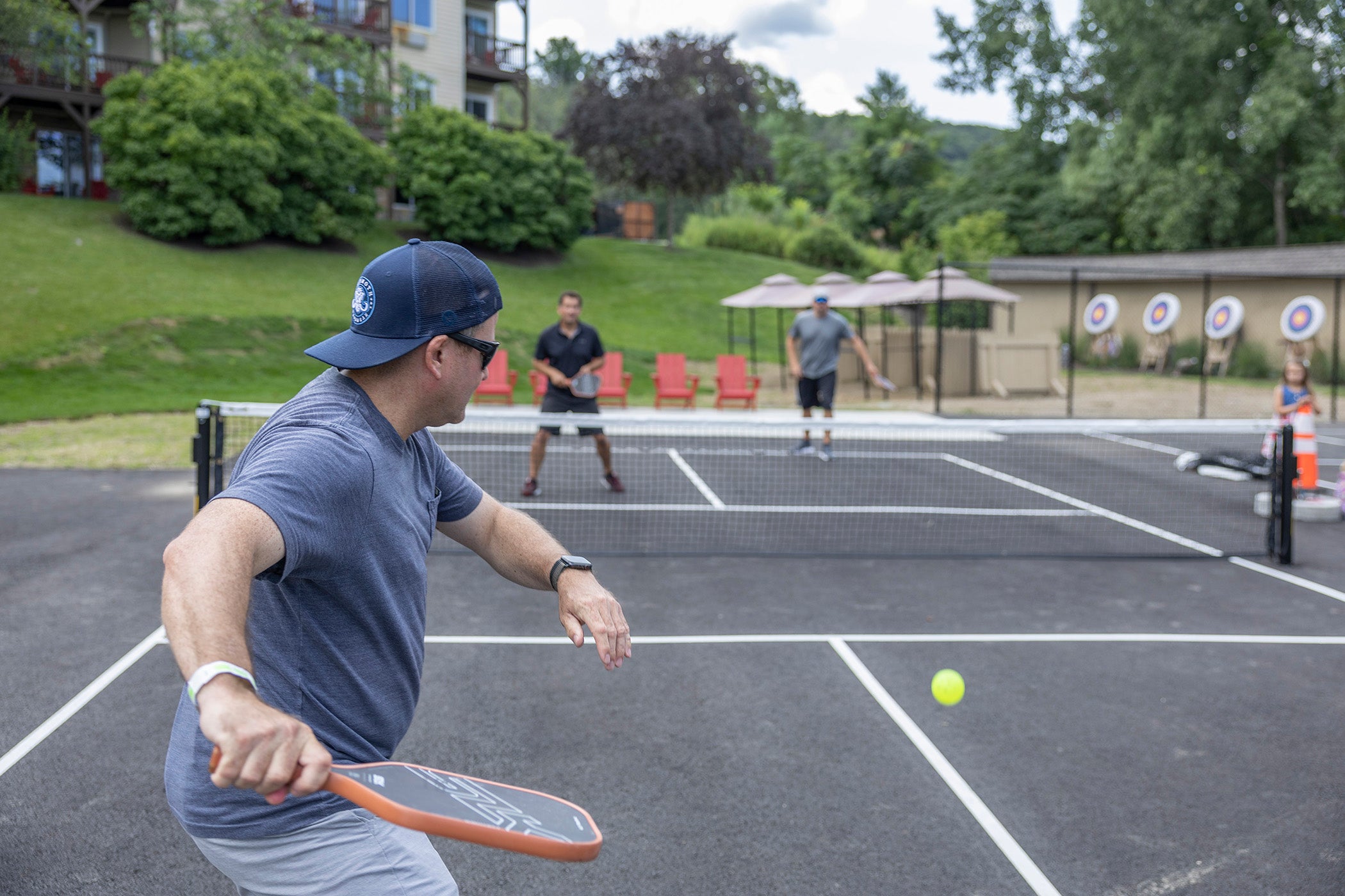 Man getting ready to hit ball over pickleball net.