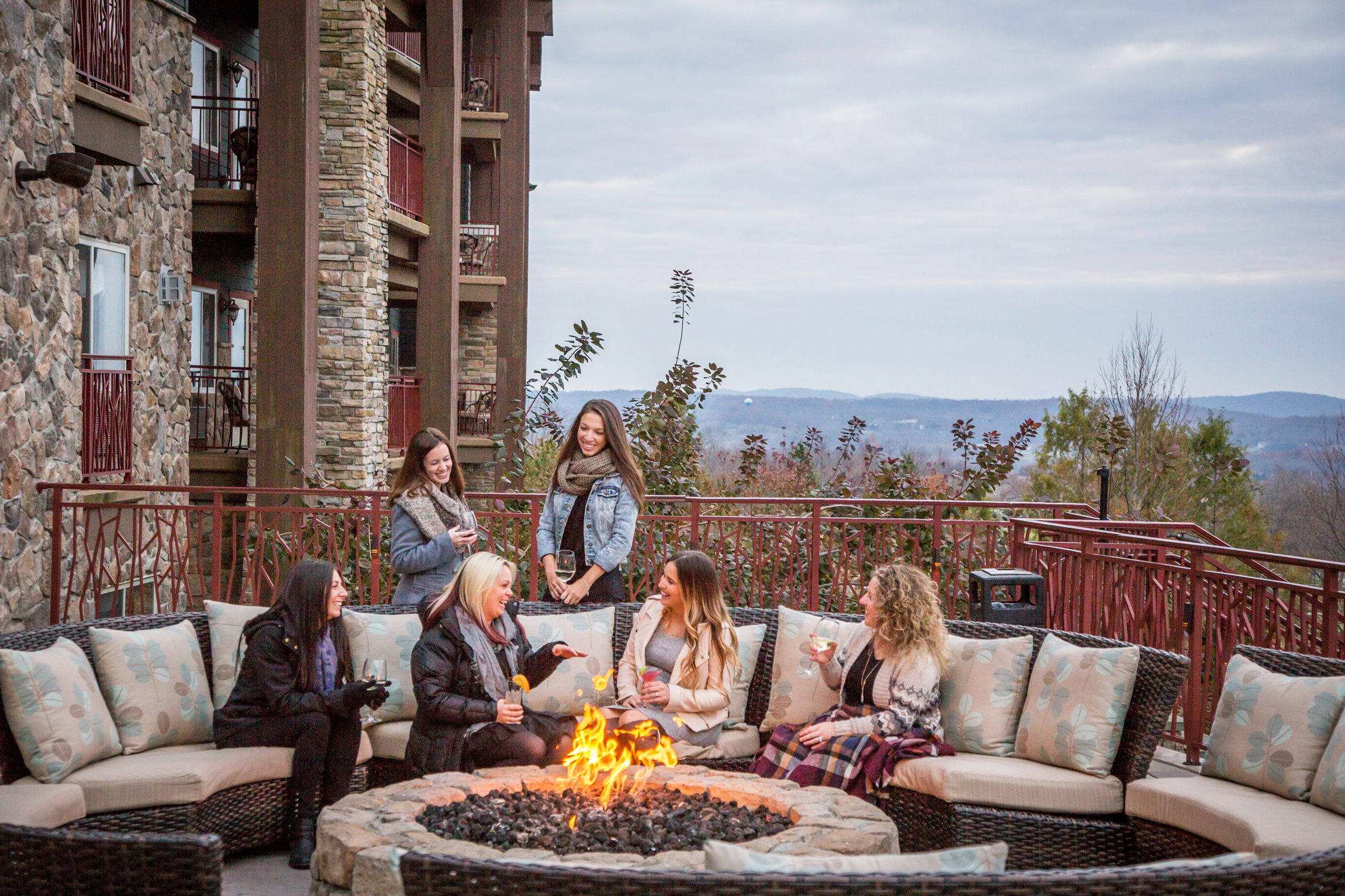 Group of girlfriends sitting around a fire.