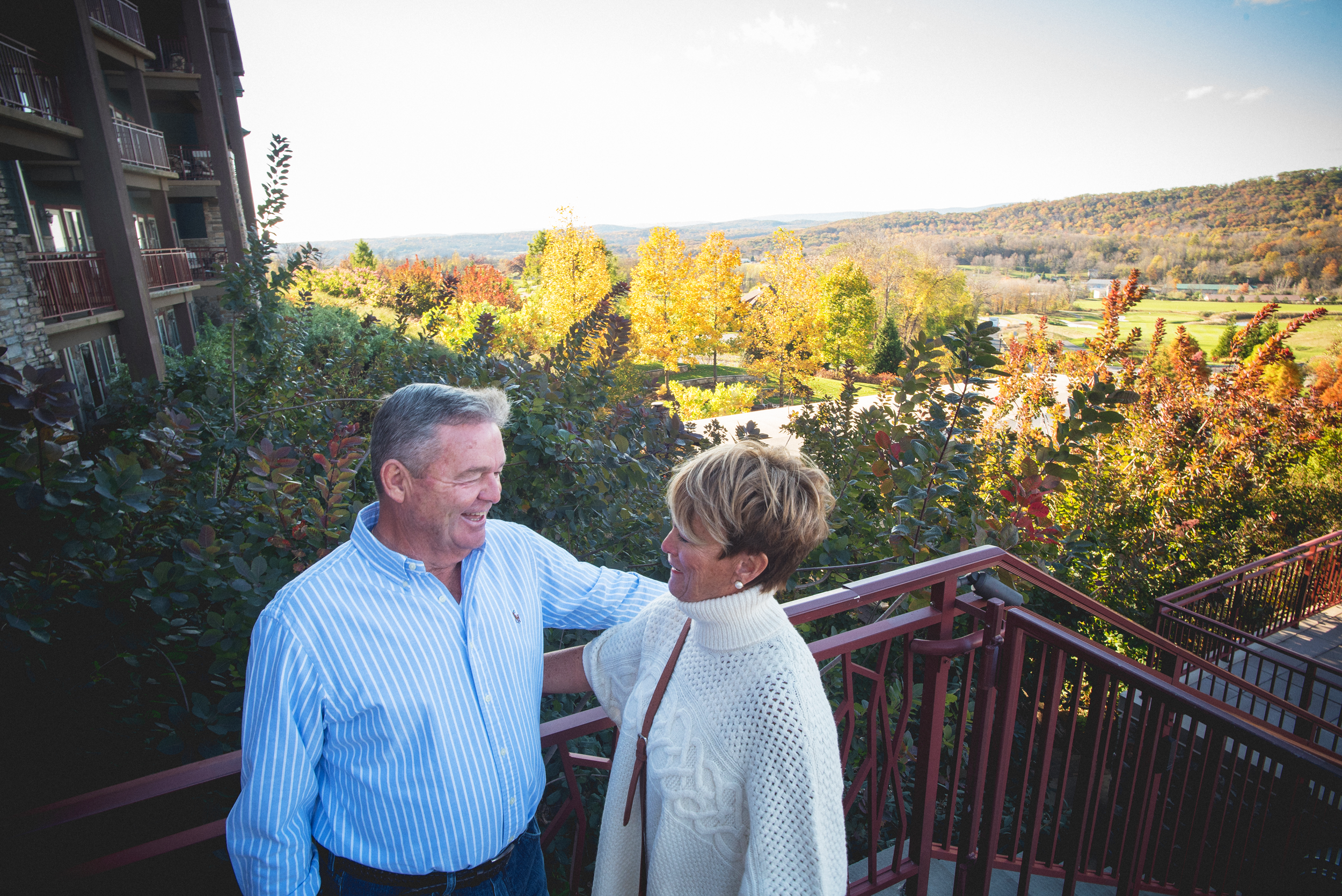 Couple staning on Fire &amp; Water Terrace at GCL overlooking fall foliage.