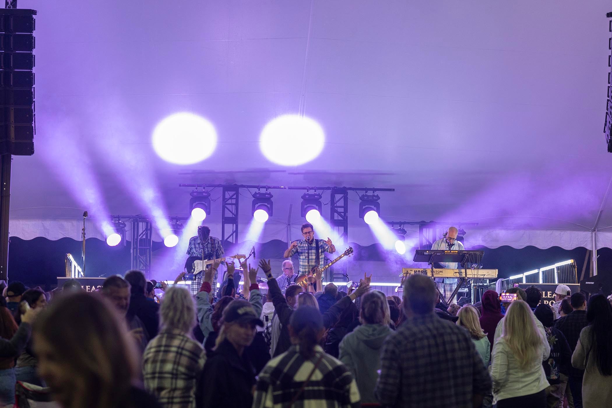 The Nerds on stage at music fest with bright lights illuminating the stage.