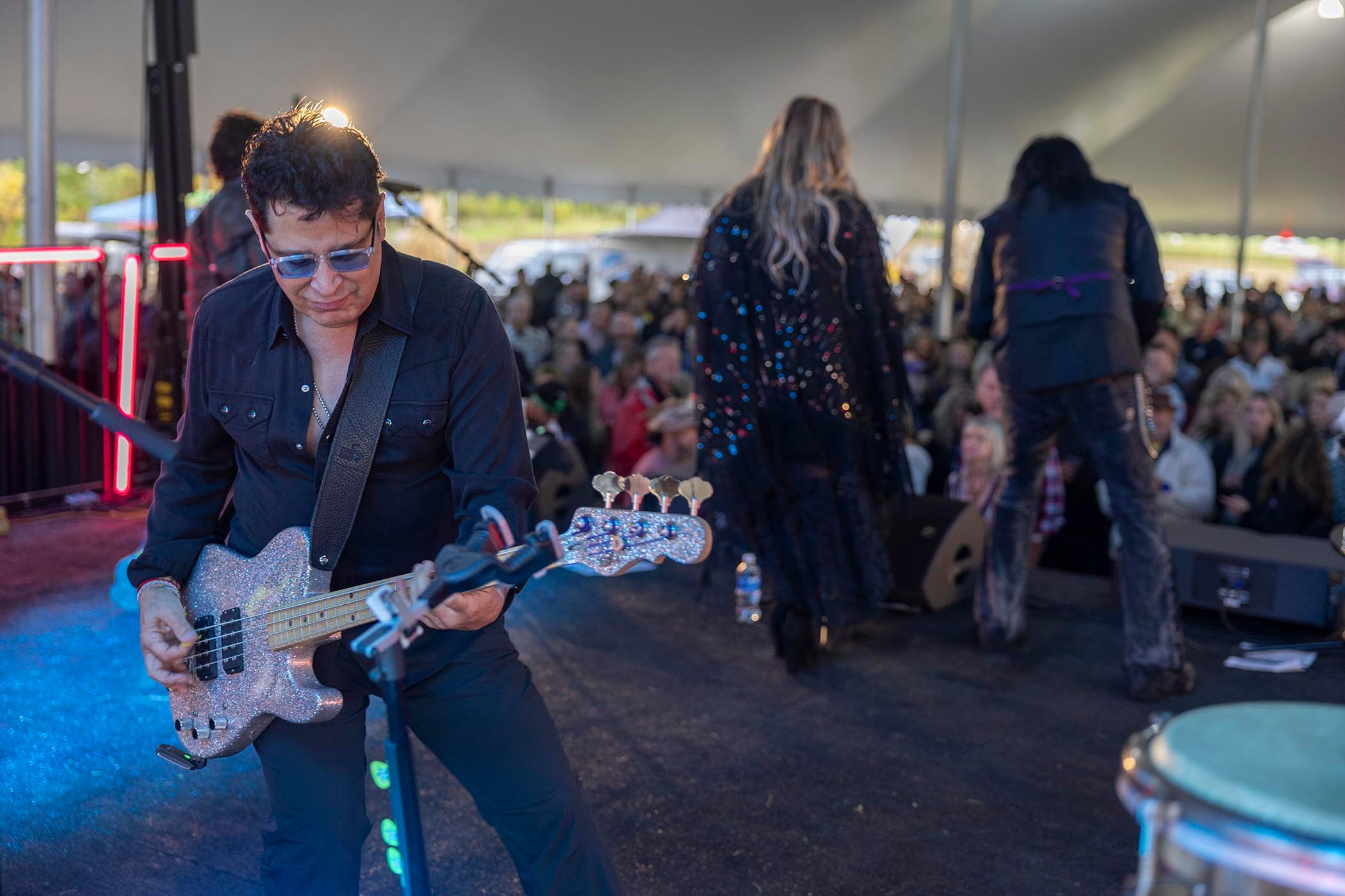 Man playing guitar on stage at music fest.
