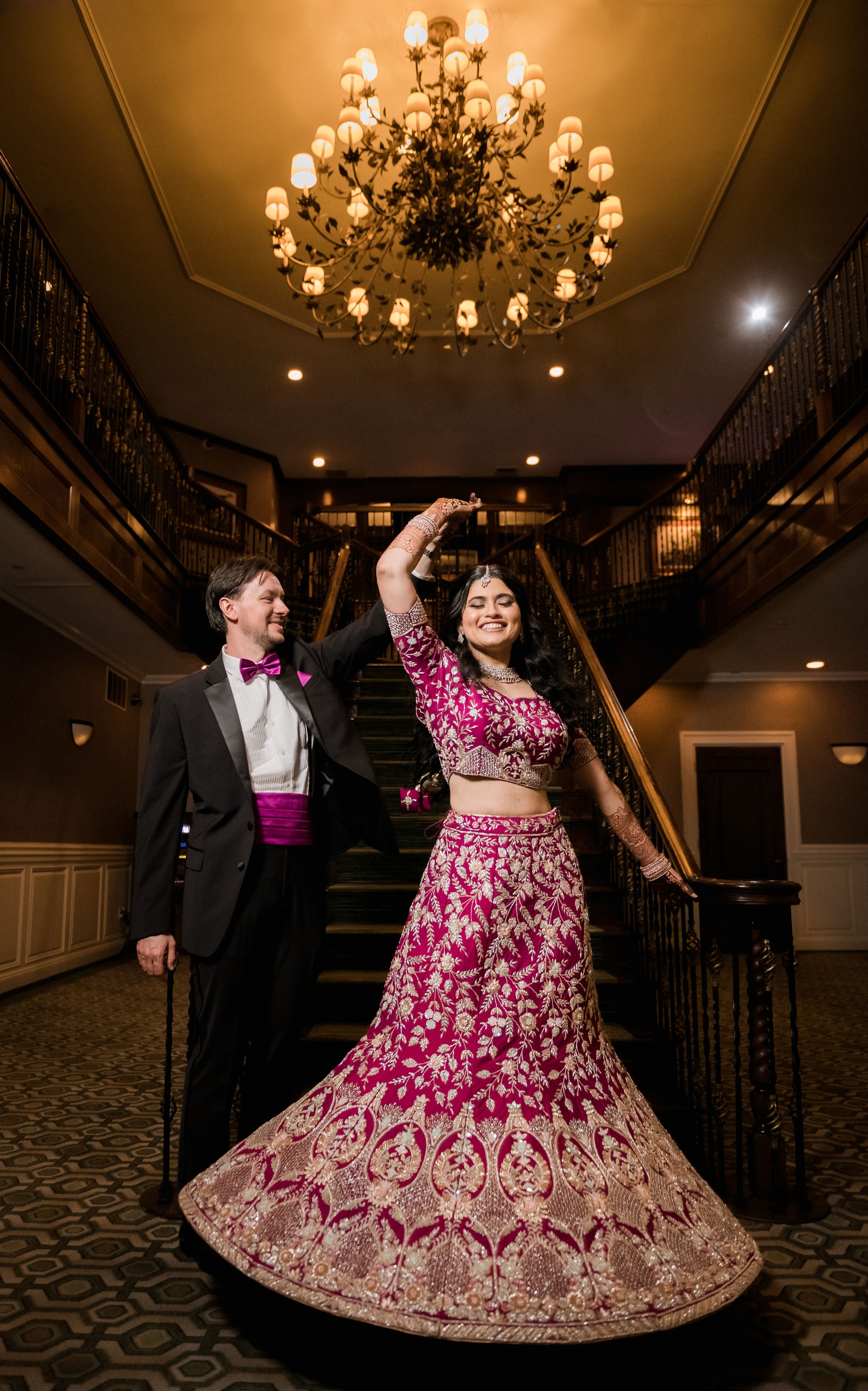 Groom twirling new bride in gorgeous traditional Indian wedding dress