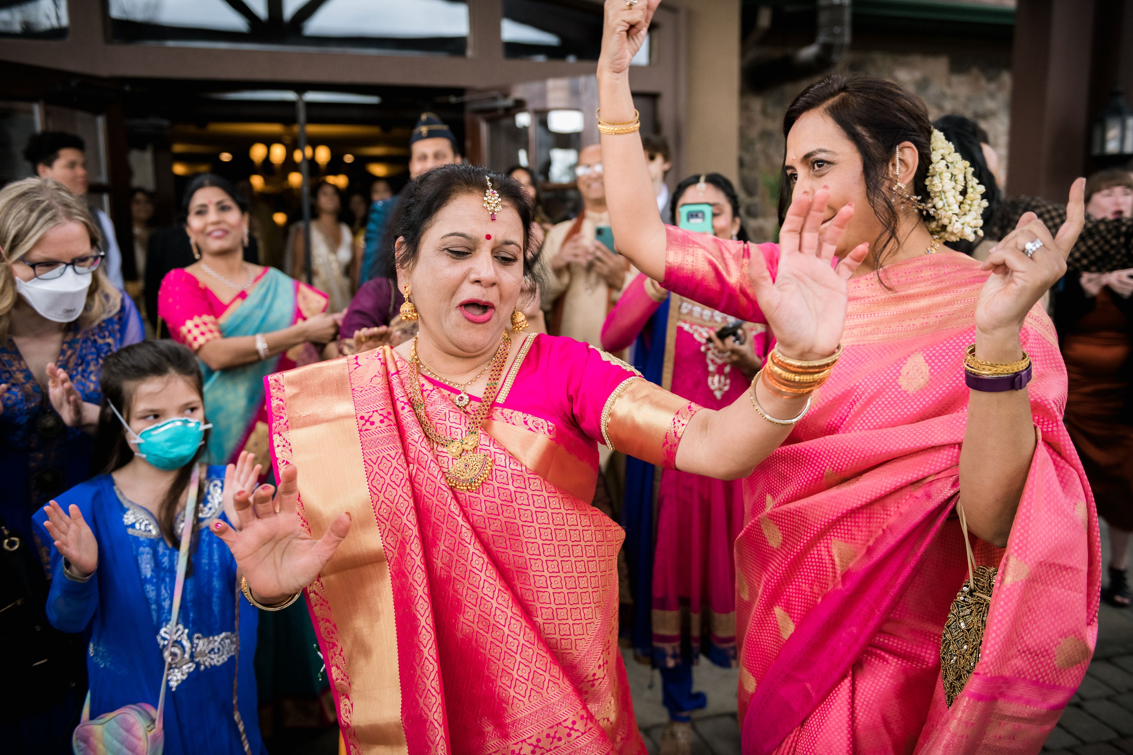 Woman dressed in sarees dancing.