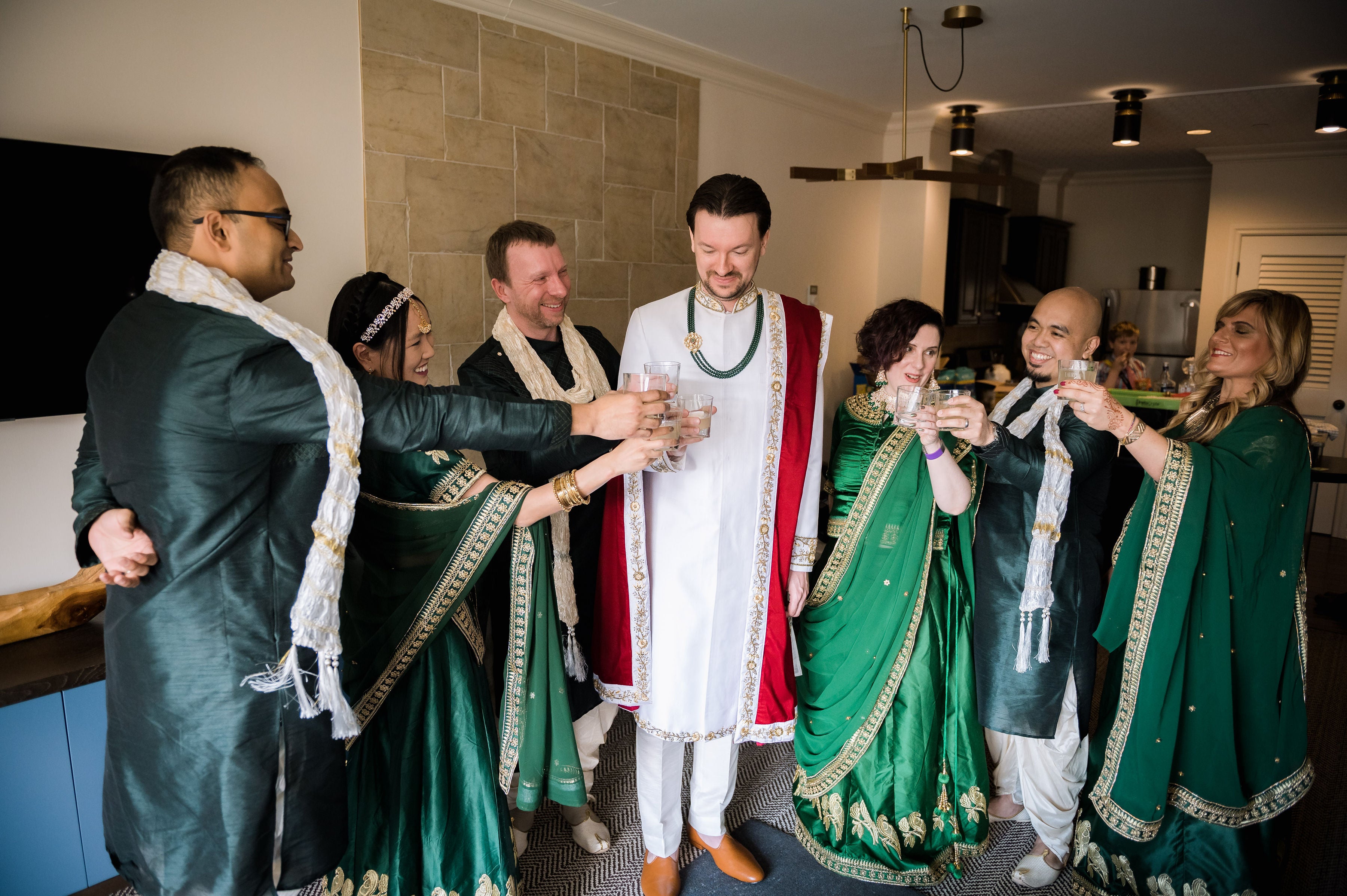 Indian groom cheersing drinks with friends and family.