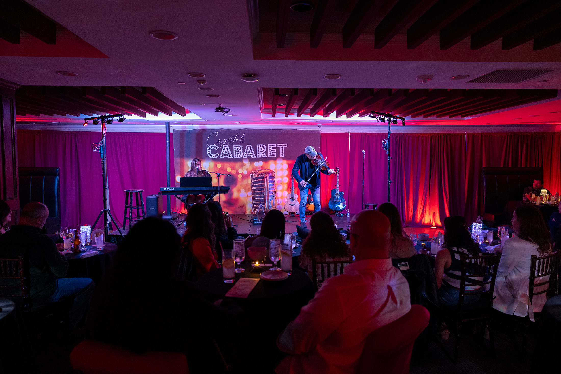 Man on Crystal Cabaret stage playing a violin.