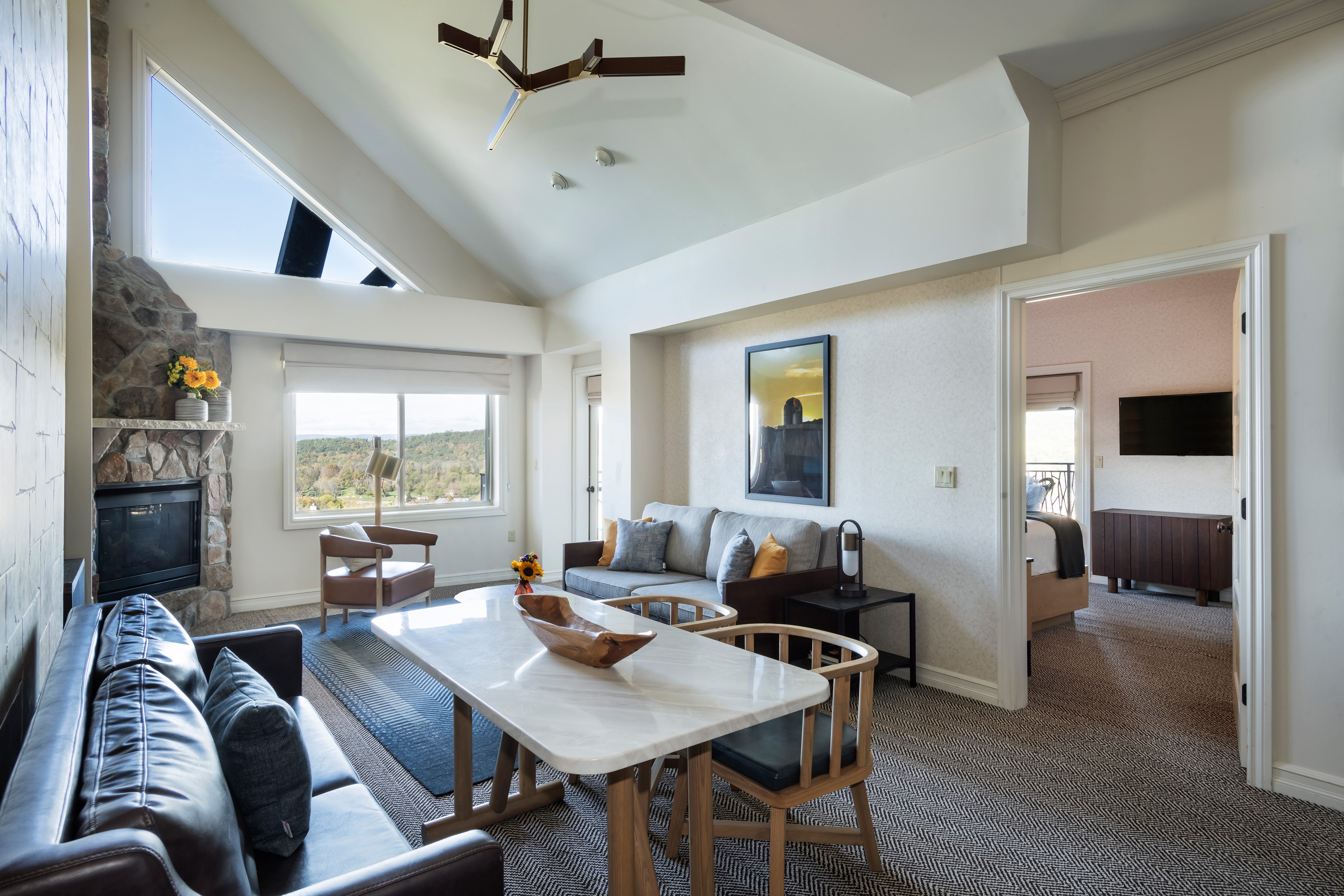 Living room with fireplace and bedroom view in the 2 bed 1 bath suite at Grand Cascades Lodge.
