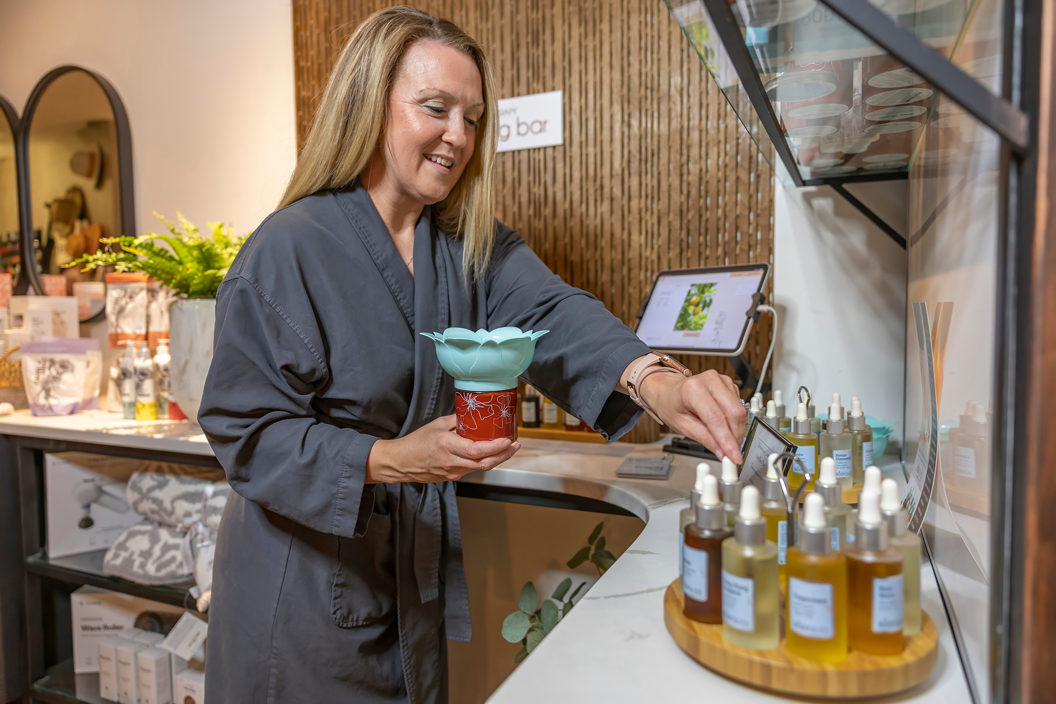 Woman creating a custom blend of oils at the Elements blend bar.