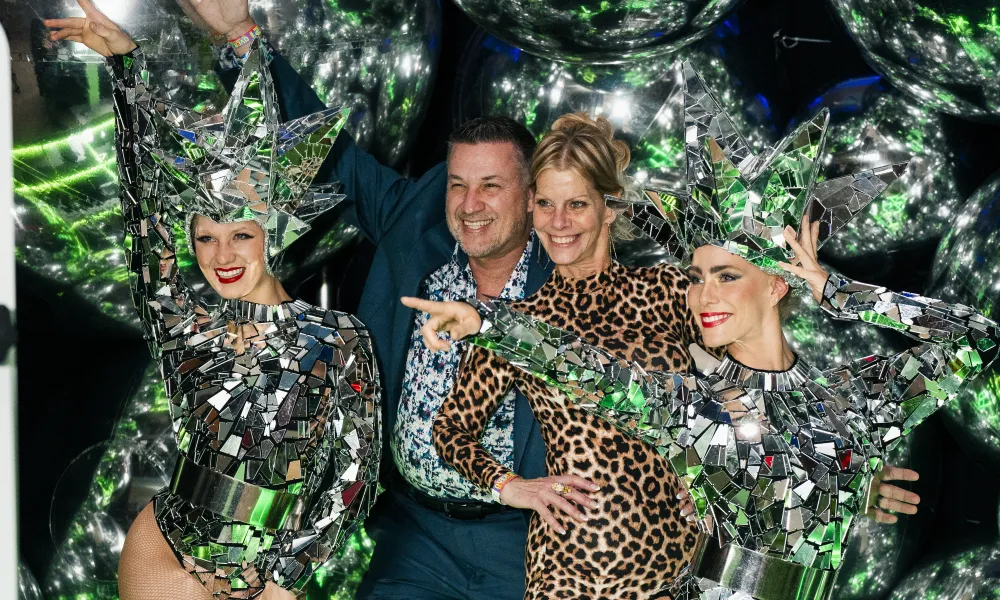 A couple posing with entertainers at a glamorous night club party.