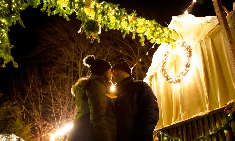 Man and woman sharing kiss under mistletoe at Frosty's Cantina