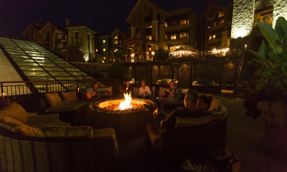 Group of people sitting around a fire on the Fire & Water Terrace