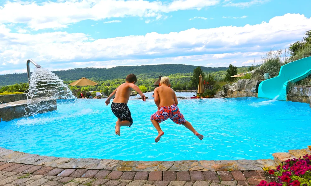 Two children jumping into vista 180 pool.