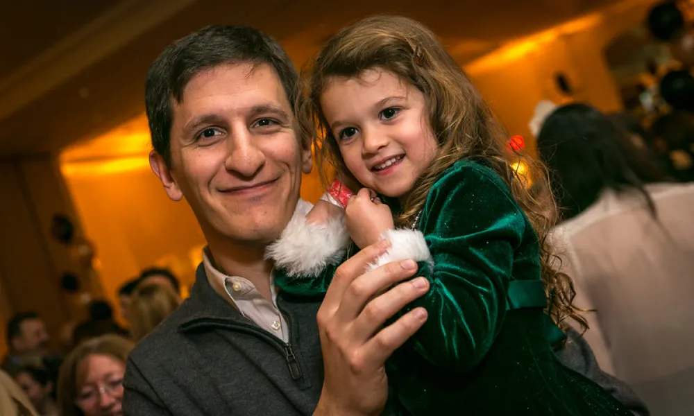 Father holding his young daughter celebrating New Year's Eve.