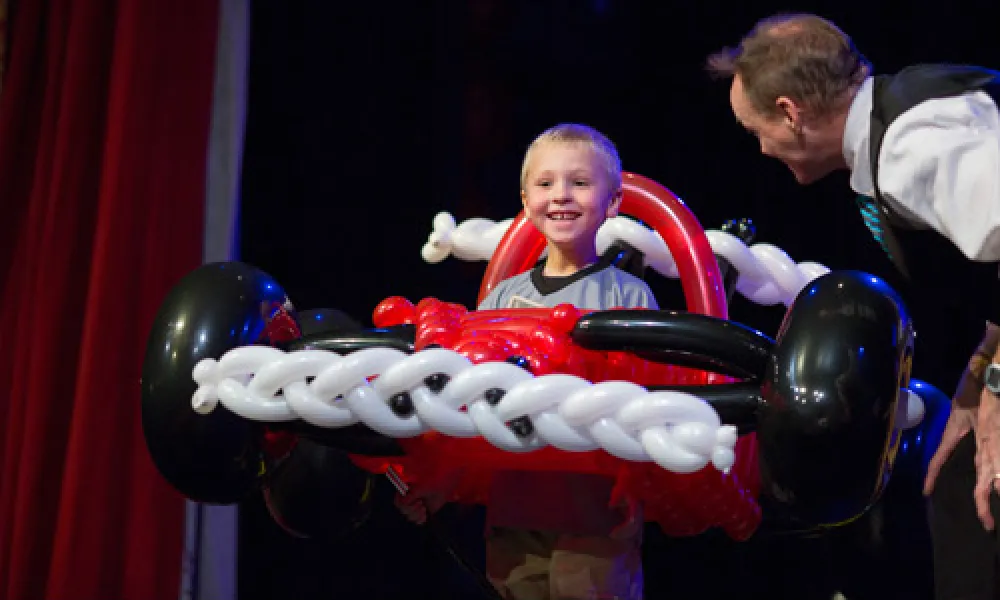 Balloon artist, John Cassidy, on stage with car made out of balloons.