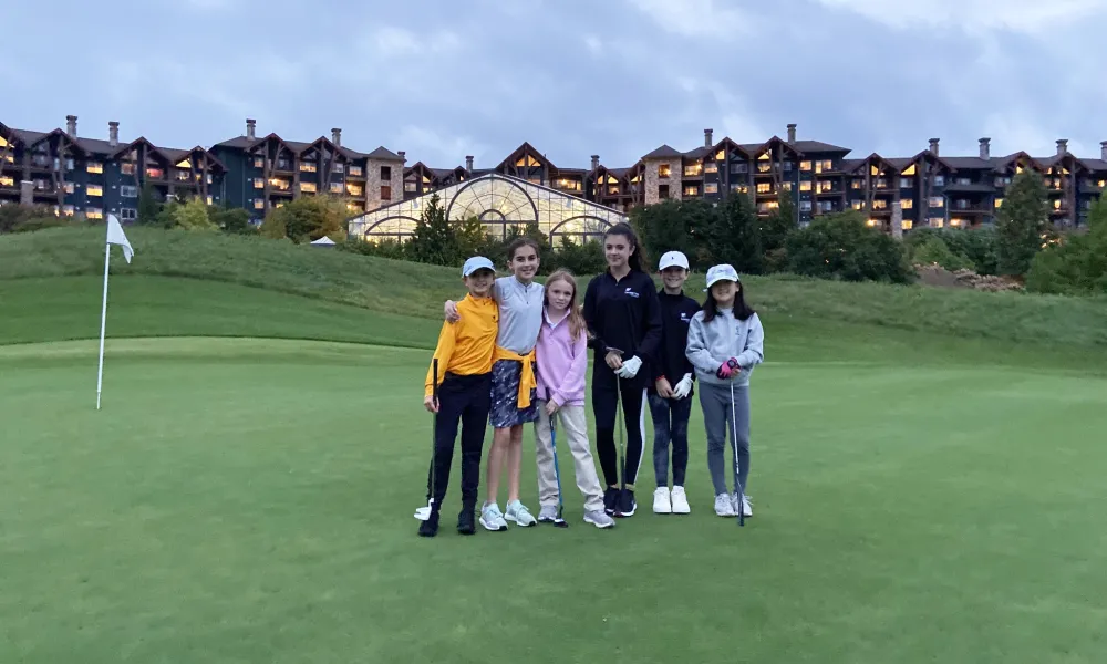 Kids learning to golf with Leadbetter Golf Academy in front of Grand Cascades Lodge