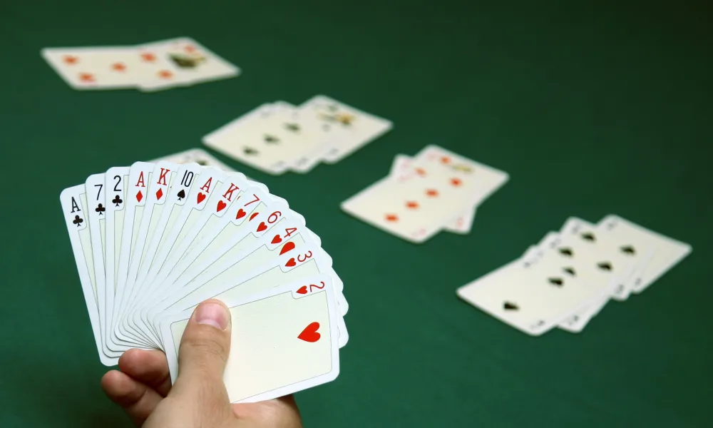 Hand holding spread out playing cards.