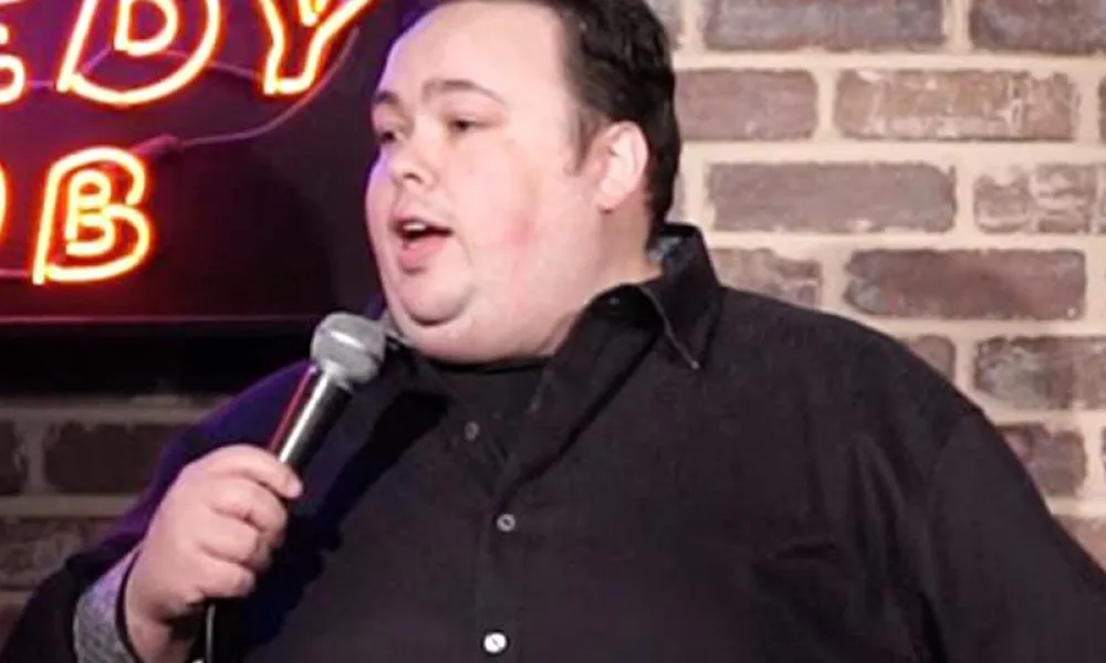 Mike Keegan on stage with microphone.