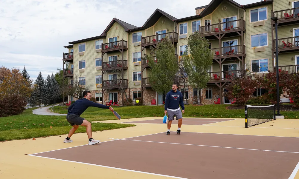 Two men playing pickleball behind Minerals Hotel.