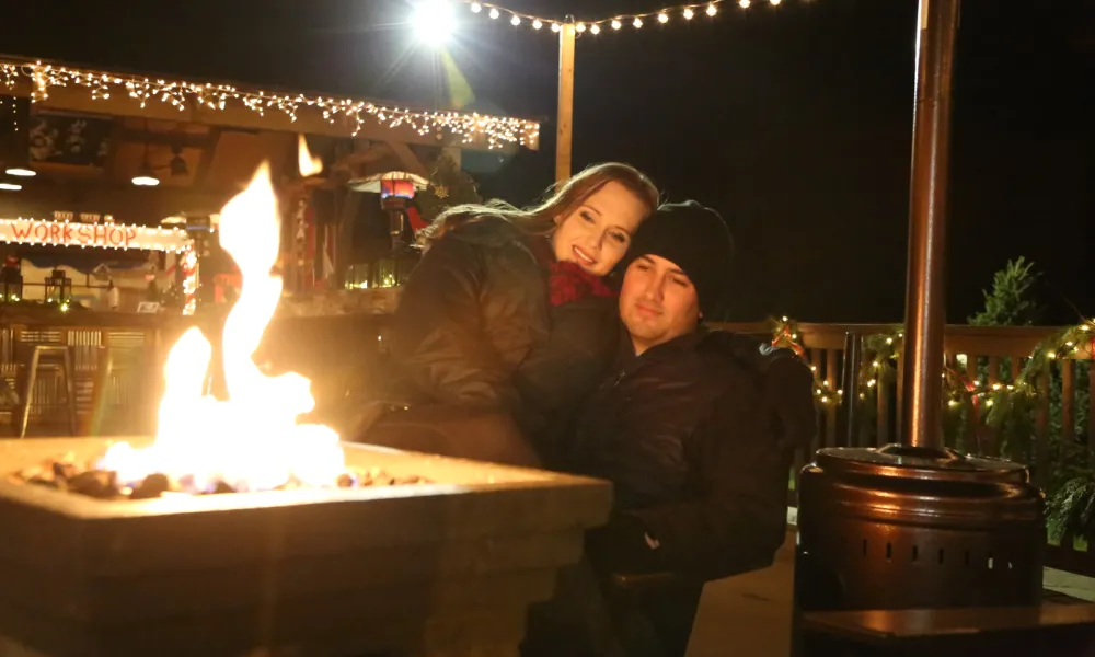 Couple sitting by firepit.