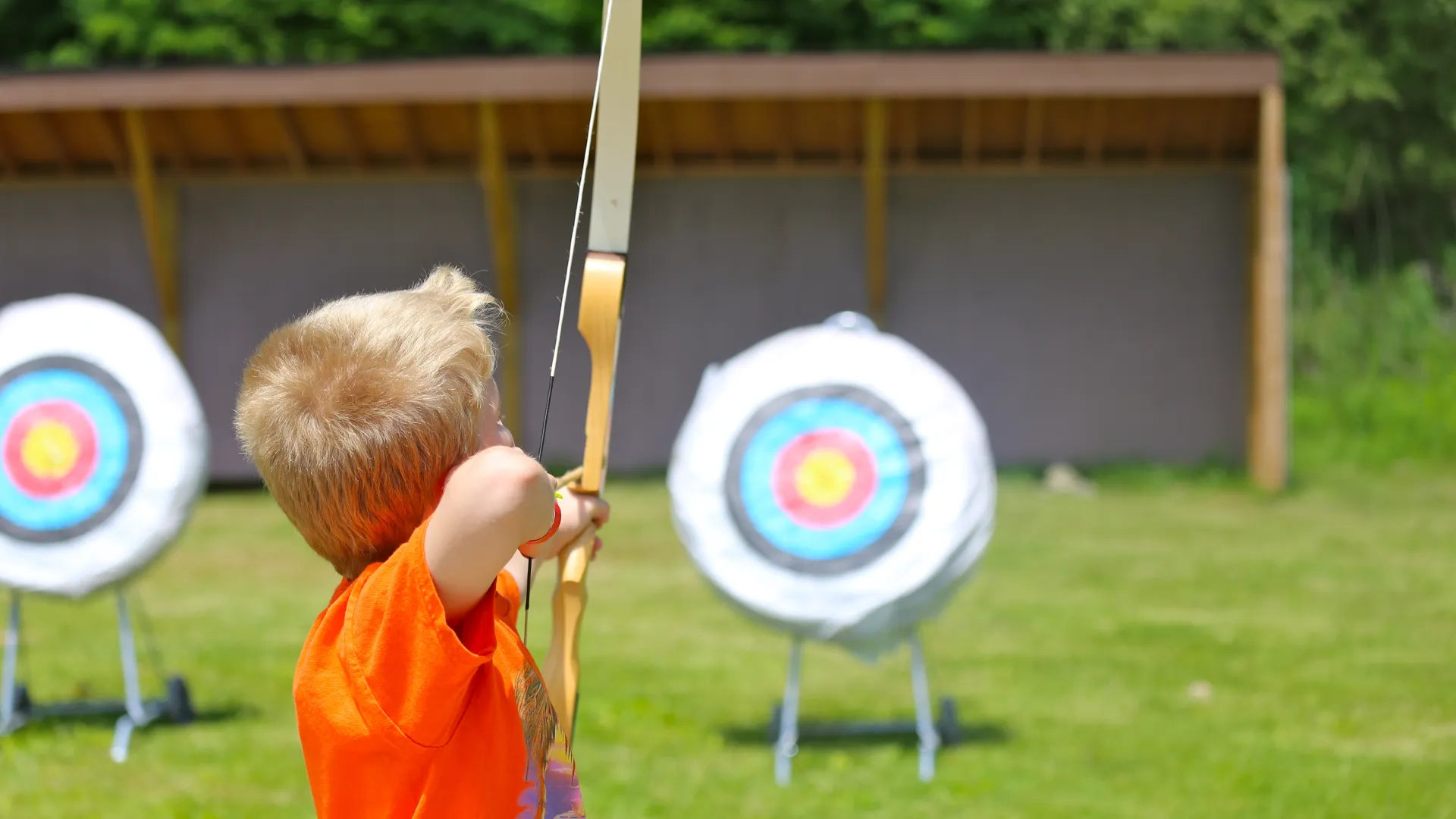 Boy shooting an arrow at a target. 