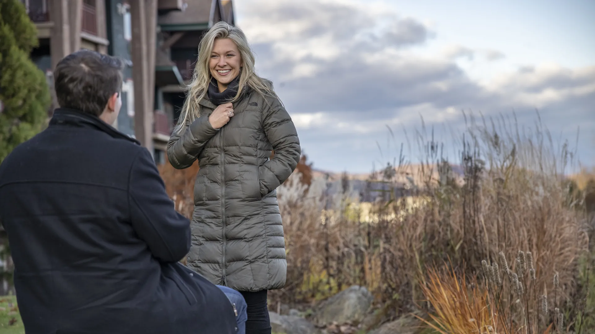 Man kneeling and proposing to a woman.